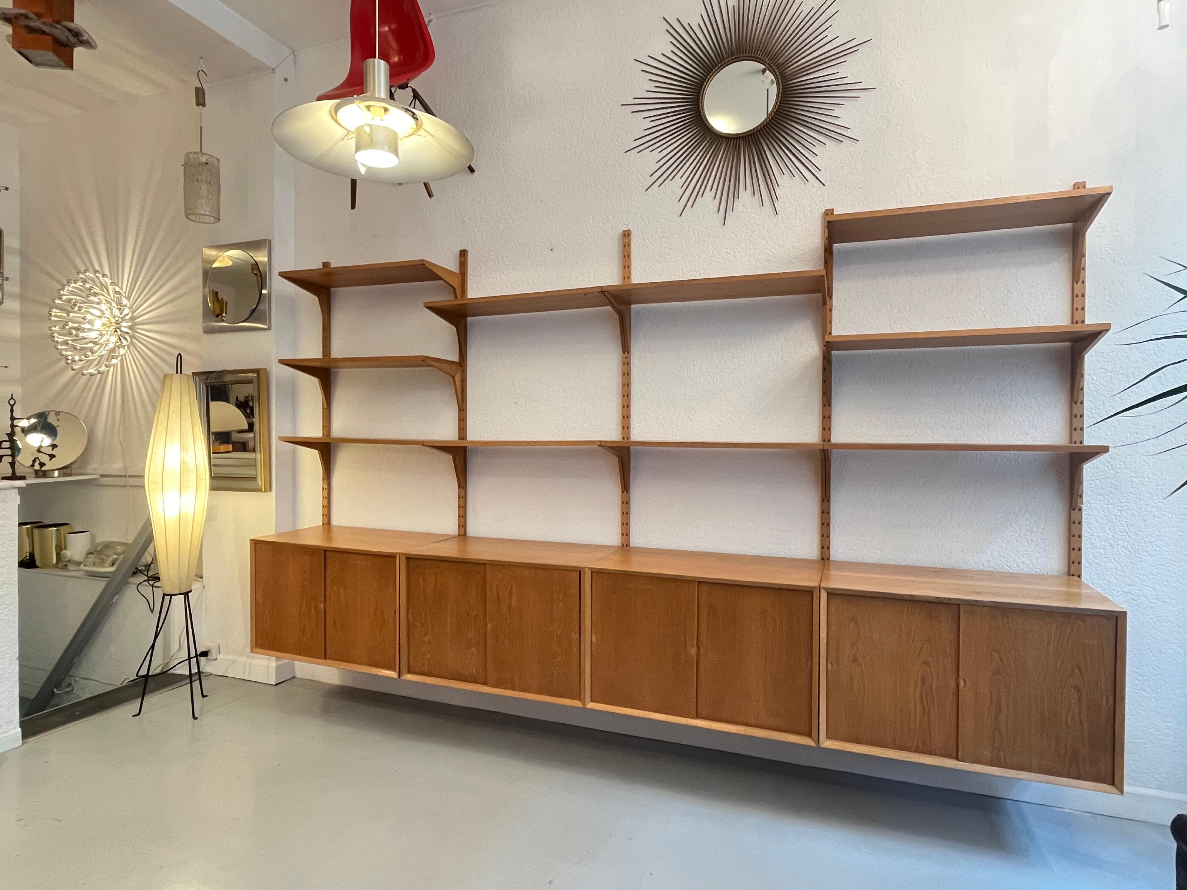 Royal System Oak modular shelving system by Poul Cadovius produced by his own company CADO in Denmark ca. 1960s.
4 cabinets  ( W80 x D46 x H51 cm with sliding doors and small drawers inside.
10 shelves of 80 x 30 cm
5 wall pole
Good vintage