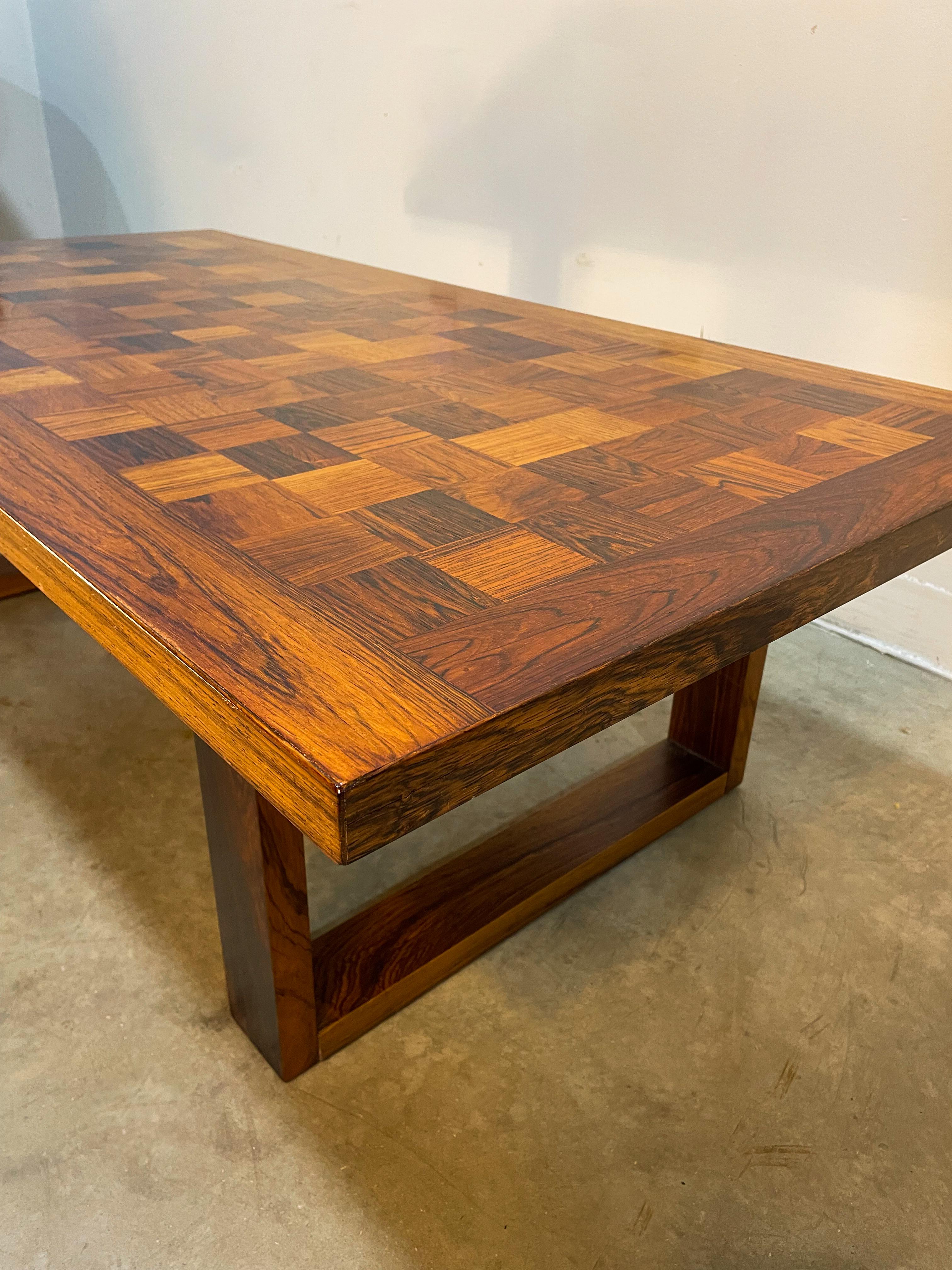 Rare Rosewood coffee table with checkerboard/parquet design by Poul Cadovius for his company CADO (maker's tag underneath). Beautiful variation in the wood grain across the top and stylish sled base legs make this a head-turner. The table is in good