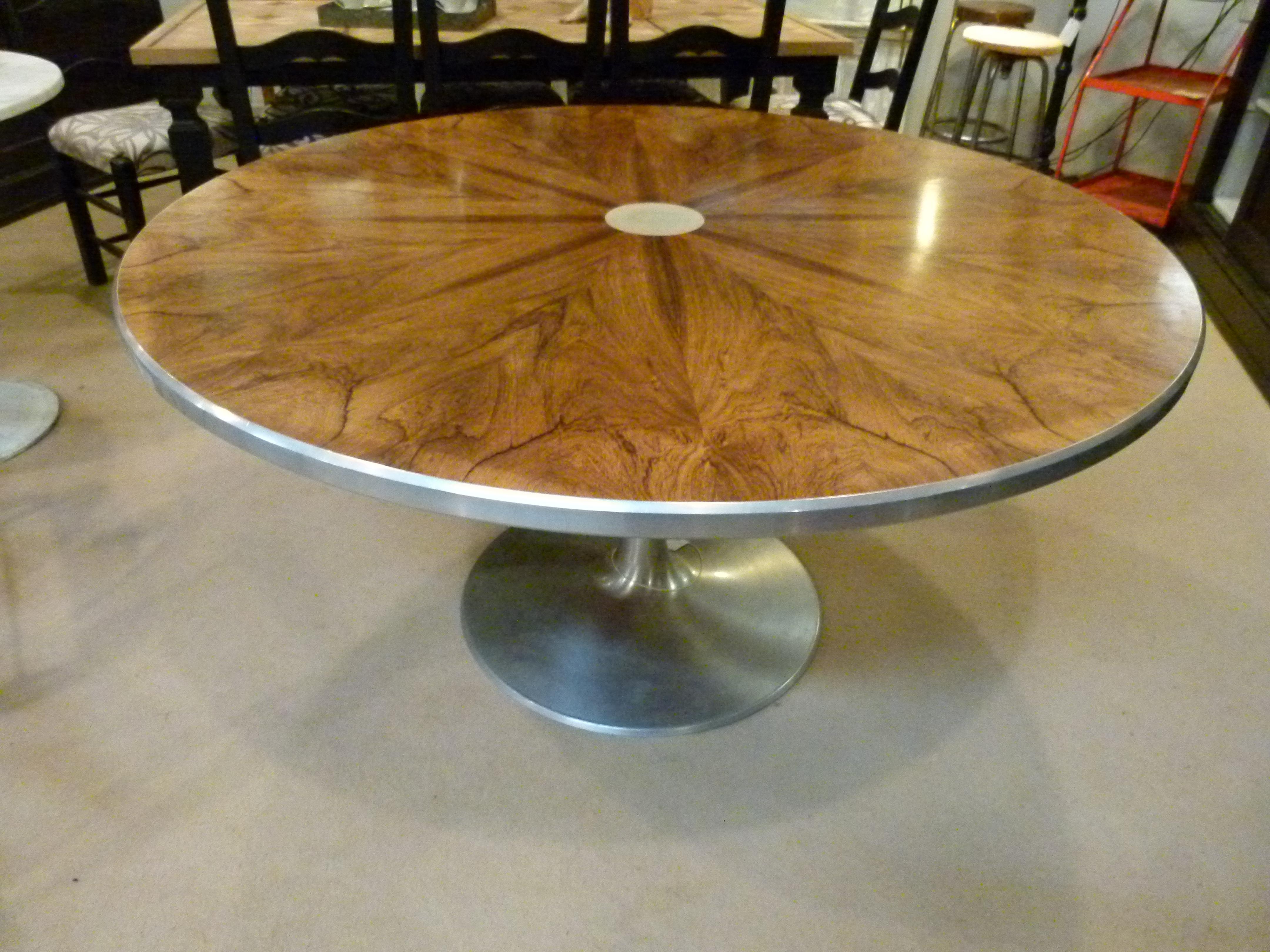 A beautiful dining or center table with a rosewood sequence matched veneer top in a radiating pattern around an inlet aluminium circle, with aluminium trim and aluminium pedestal extending into a round base.
Designed by Steen Ostergaard for Poul