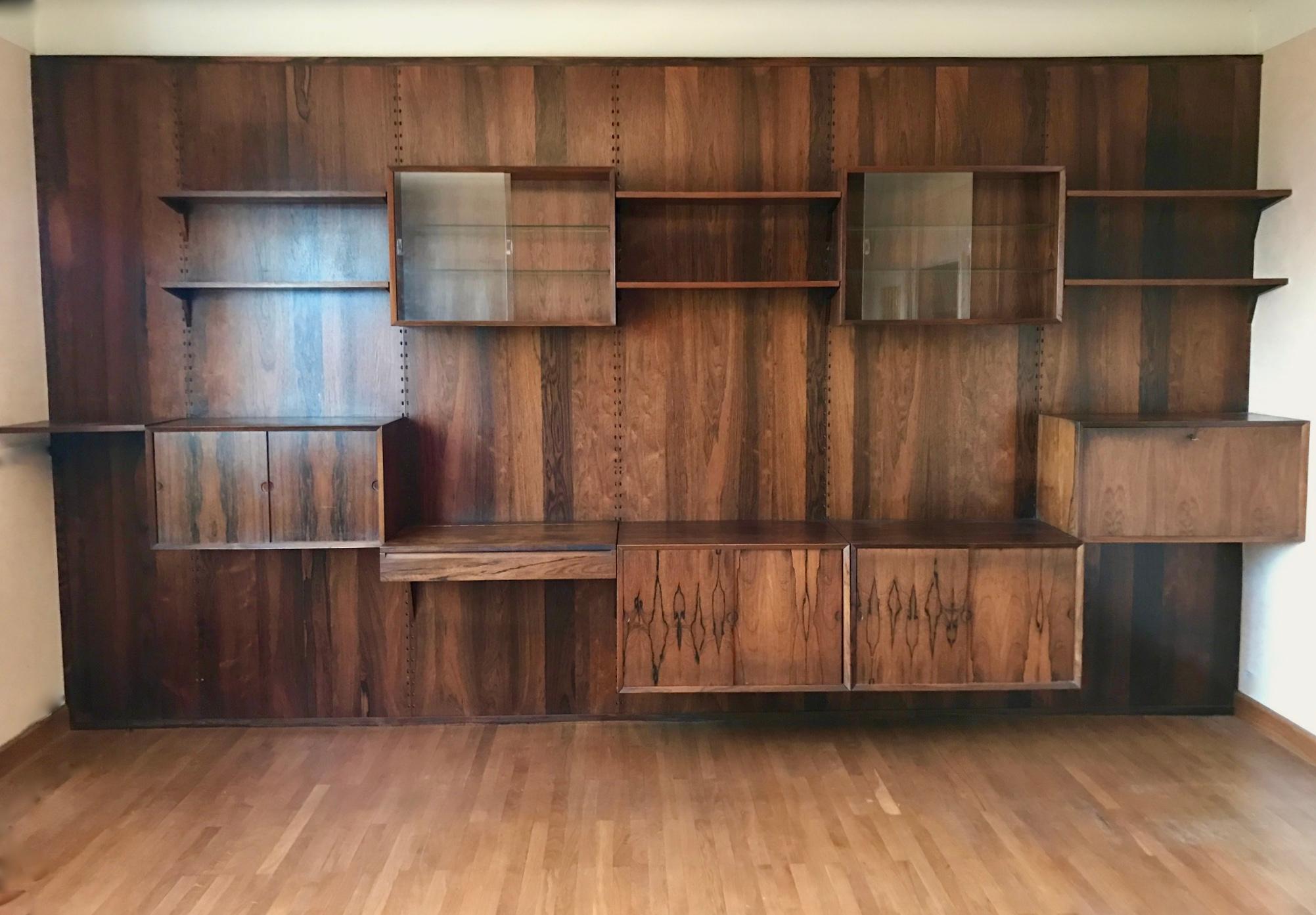 Poul Cadovius
circa 1958
Rosewood large unit, shelving system by Cado Denmark
very good condition
The wood veneer has a uniform color, there is no lack of veneer, the furniture can be sharpened according to the wall

Glass showcase and sliding