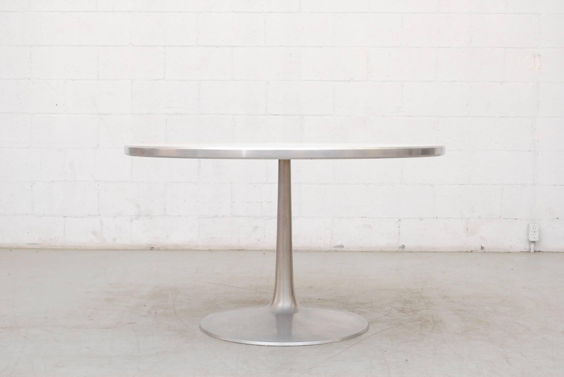 Elegant Poul Cadovius 1960s round dining table with an aluminium frame and white melamine top. In original condition with visible scratches to aluminium and top. Manufactured by France & Son, Denmark.