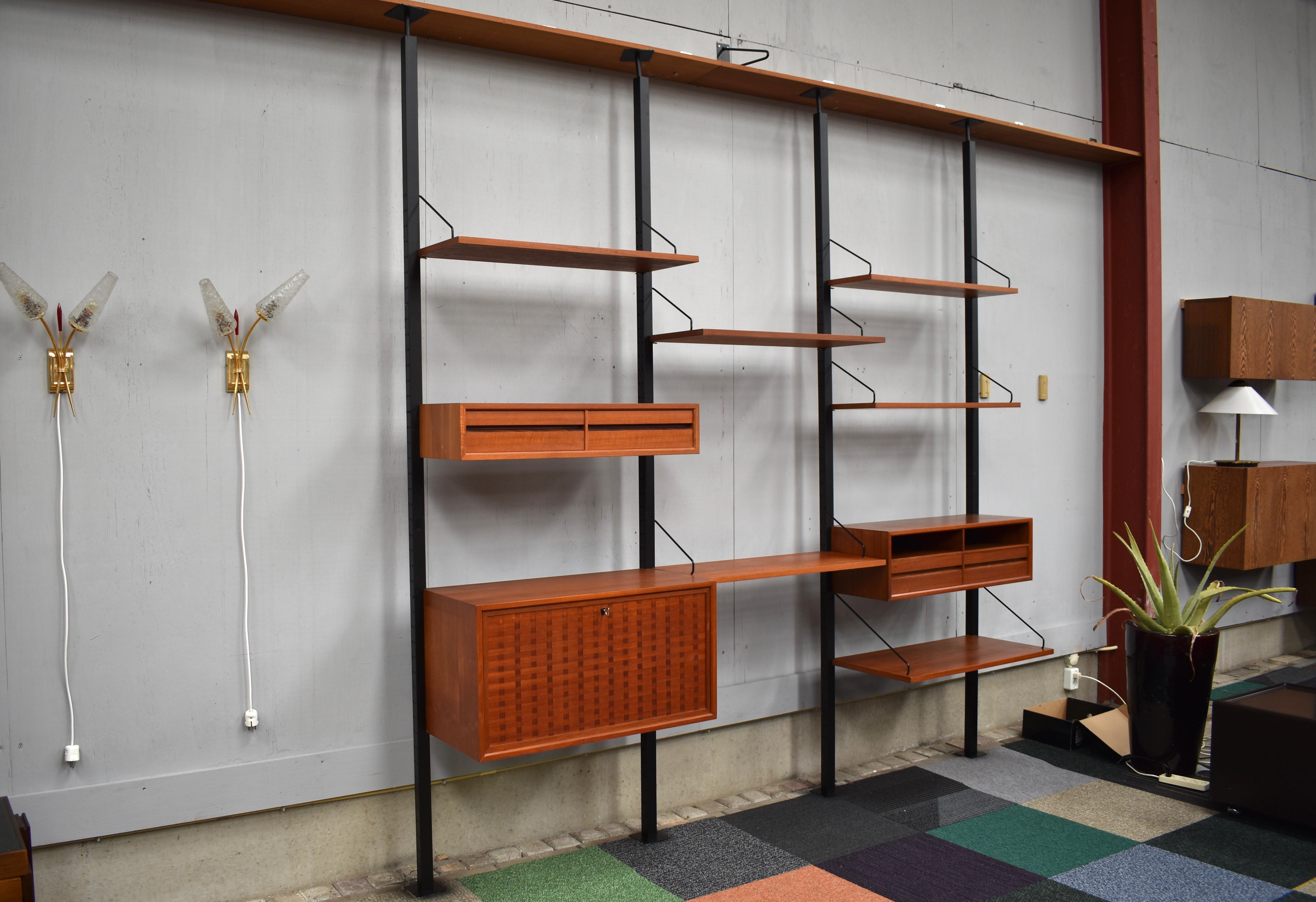 Very rare modular Royal series wall unit in teak by Poul Cadovius, Denmark, 1960s.

This unit has four of the rare free standing mounting pillars that can be used as a room-divider. The pillars are clamped between floors and ceiling, in the top is