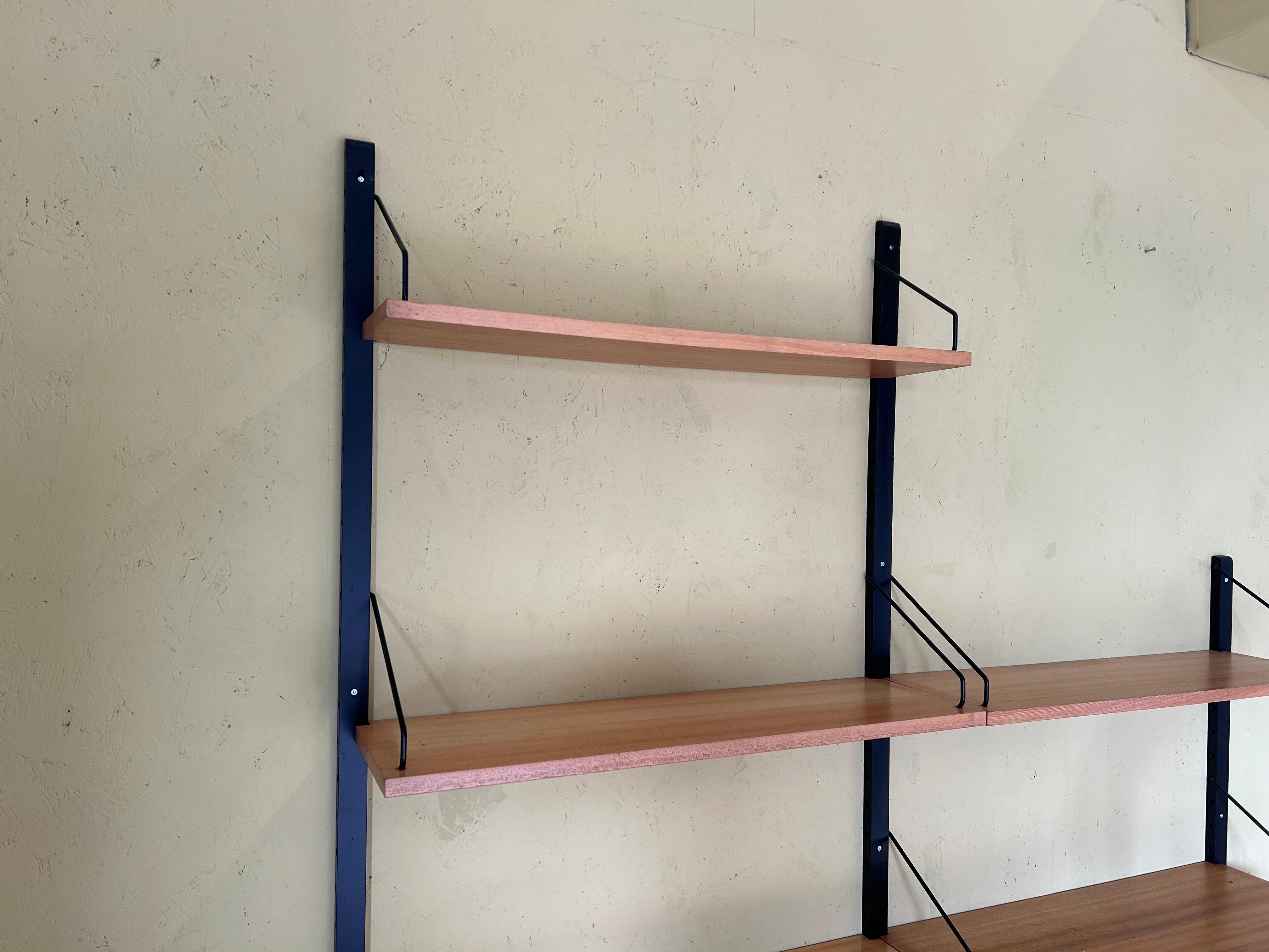 Danish modern teak wall unit designed by Poul Cadovius, Denmark, circa 1960s.

This piece is contains of 4 shelves and one cabinet with sliding doors.


This piece is completely adjustable, and any of the case pieces or shelves can be installed