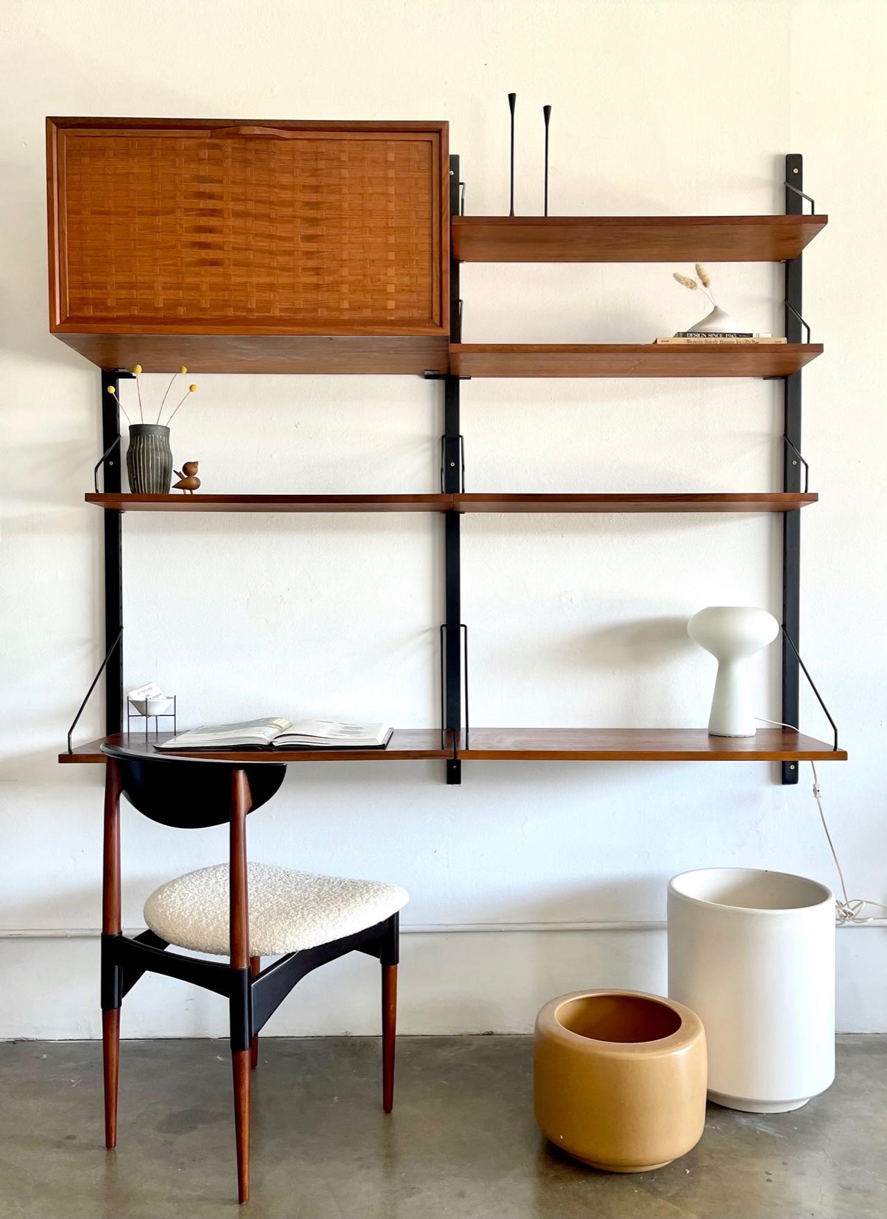 Poul Cadovius Royal system wall unit in teak, ca. 1965. Unit is in very good original condition with original wall mounts that have been painted black for a nice contrast. Teak basketweave box can hold media, papers or glassware. Two of the lower