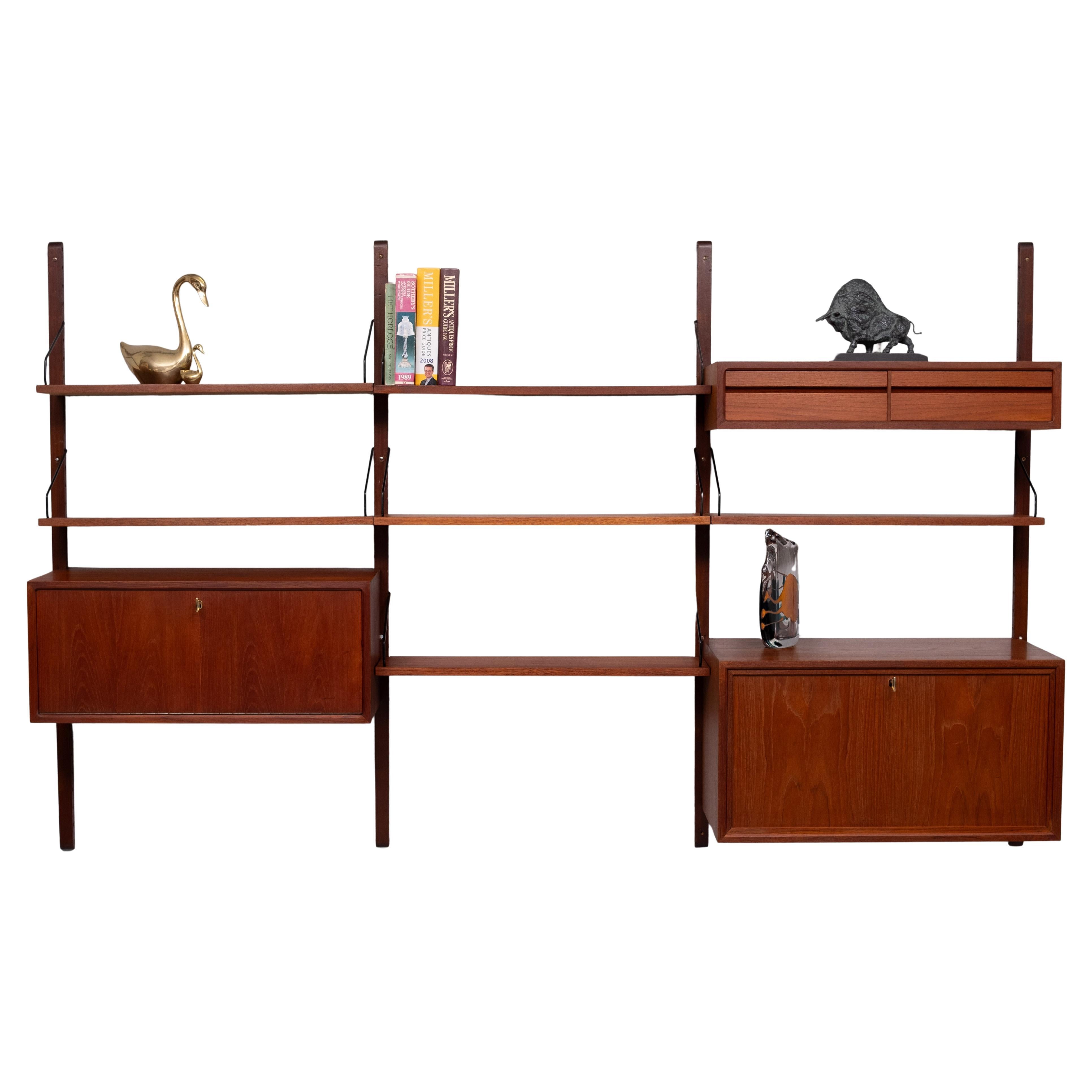 For sale this iconic modular Wall system .Teak . 3 cabinets and 6 shelves 
comes with 4 uprights and al the hardware . This system gives you the 
freedom to change the positions of the cabinets and the shelves .
One cabinet with a fall down door