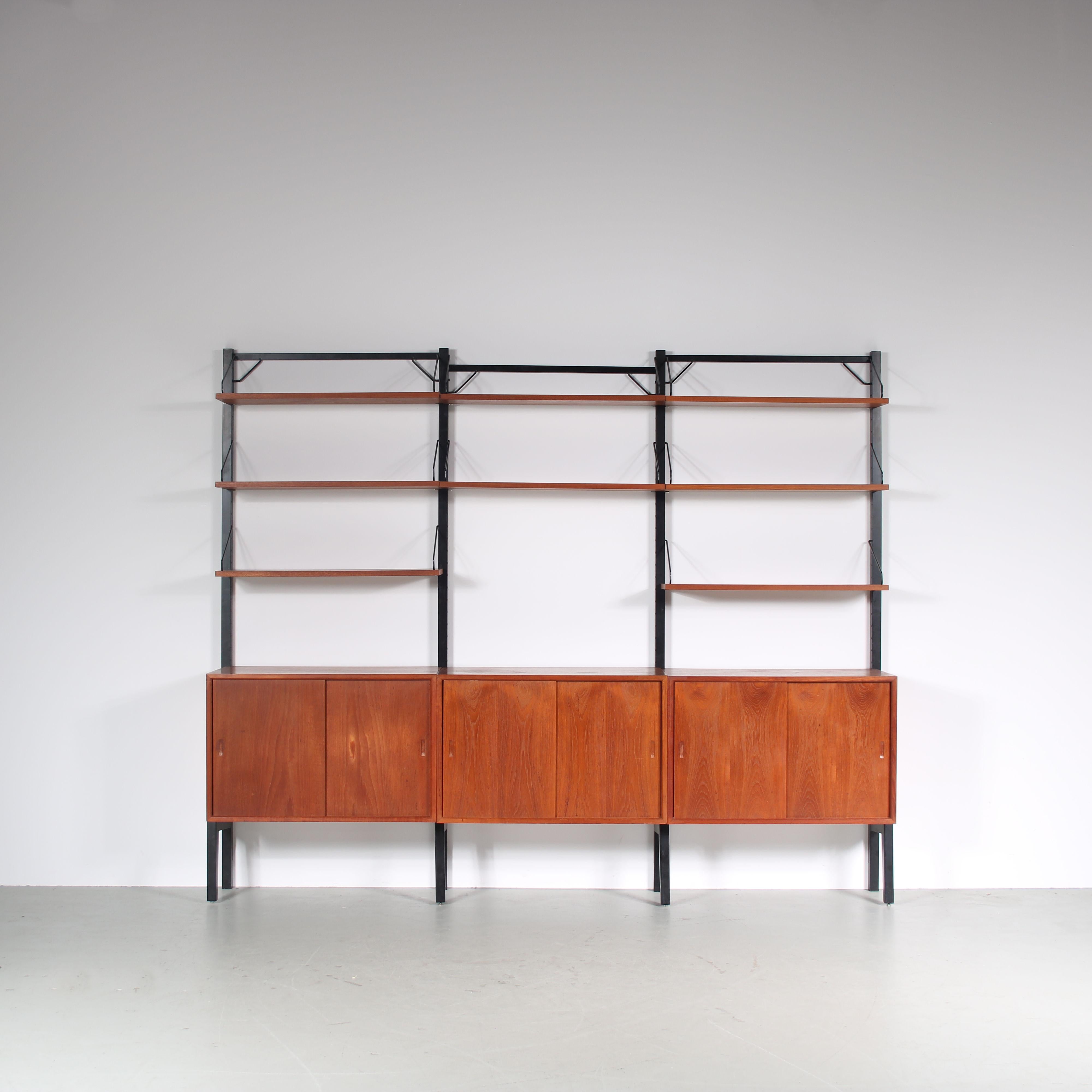An eye-catching wall mounted system cabinet designed by Poul Cadovius, manufactured by Royal System in Denmark around 1960.

A beautiful piece made of teak wood in a warm brown colour. It is three units wide, having multiple shelves held by elegant