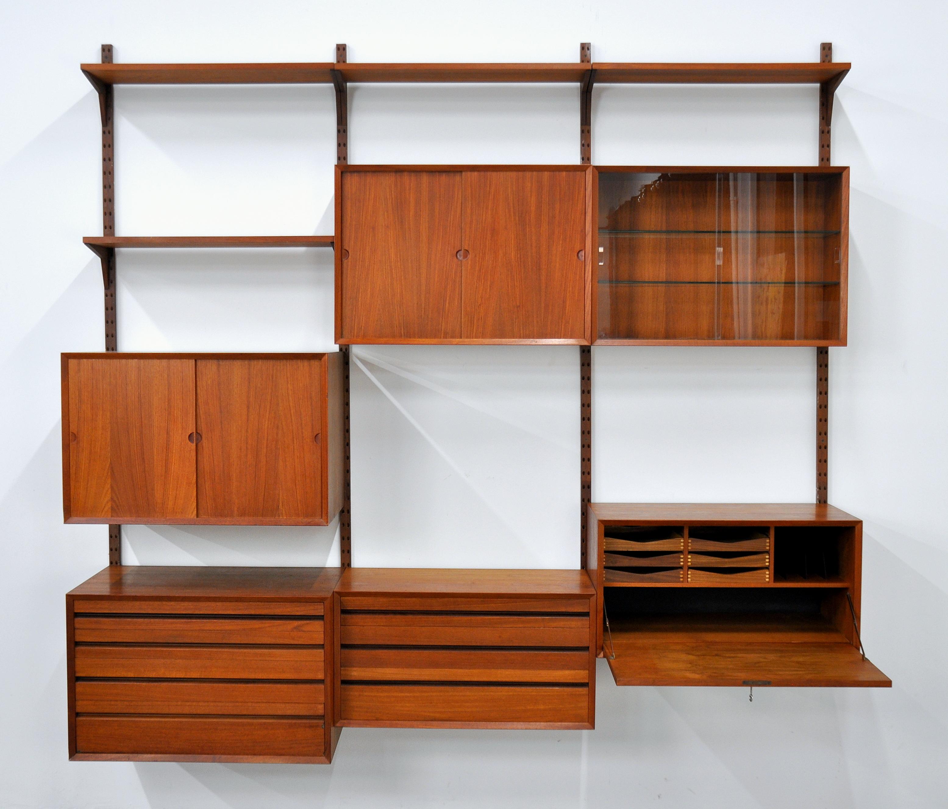 A splendid midcentury Danish Modern vintage three bay teak system, designed by Poul Cadovious and manufactured by Cado in the 1960s. The modular bookcase system includes:
- Cabinet with four drawers, 31.5 in x 18.13 in x 20.25 in H
- Cabinet with
