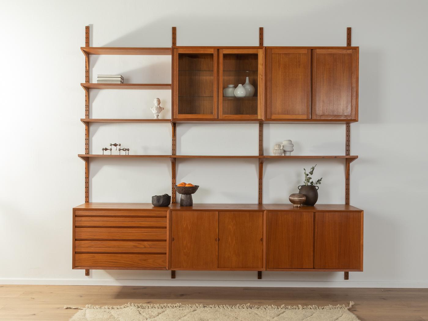 Classic shelving system from the 1960s. The high-quality containers and shelves are veneered in teak. The system consists of six shelves, two containers with doors, one container with glass doors, one container with sliding doors, one container with
