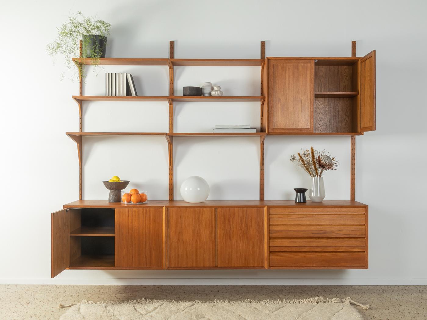 Classic shelving system from the 1960s. The high-quality containers and shelves are veneered in teak. The system consists of six shelves, three containers with doors, three shelves, a container with four drawers and four wooden ladders.

Quality