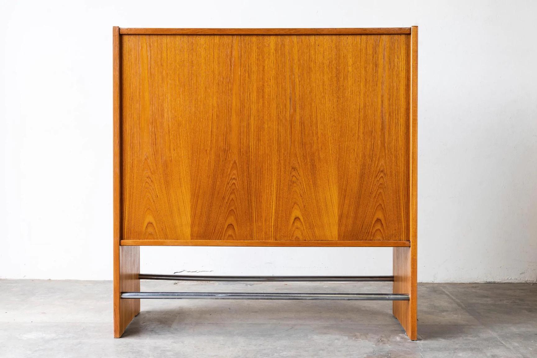 Heltborg Mobler Danish teak bar designed by Poul Heltborg. The bar has 8 bottle holders through the middle and two pull-out stainless steel ice bowls on the right as well as shelving for glassware, and a pull out small shelf. This bar is often