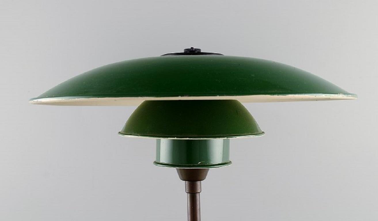 Poul Henningsen (1894-1967) for Louis Poulsen
PH 3½-2 table lamp with socket housing of brass / metal, wire shade holders mounted w / shade set of green-painted zinc. 
1940s.
Measures: Height: 45 cm.
Screen diameter: 36 cm.
Foot diameter: 16