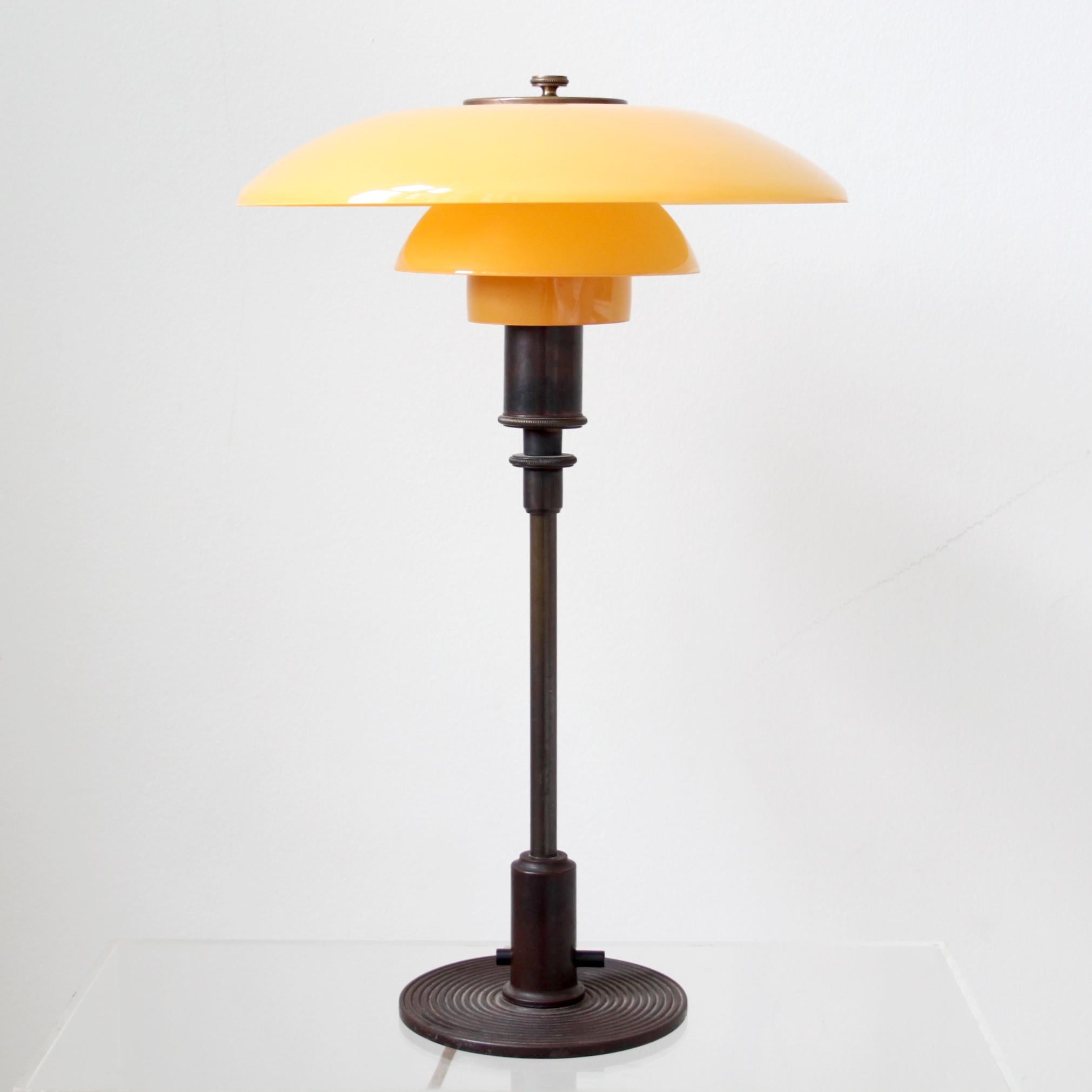 Poul Henningsen y Louis Poulsen, Modernismo escandinavo

La emblemática lámpara de sobremesa Poul Henningsen (PH 3/2) con pantallas de cristal ámbar.

Soporte y casquillo de latón dorado. Interruptor de baquelita.

En la parte superior de la base