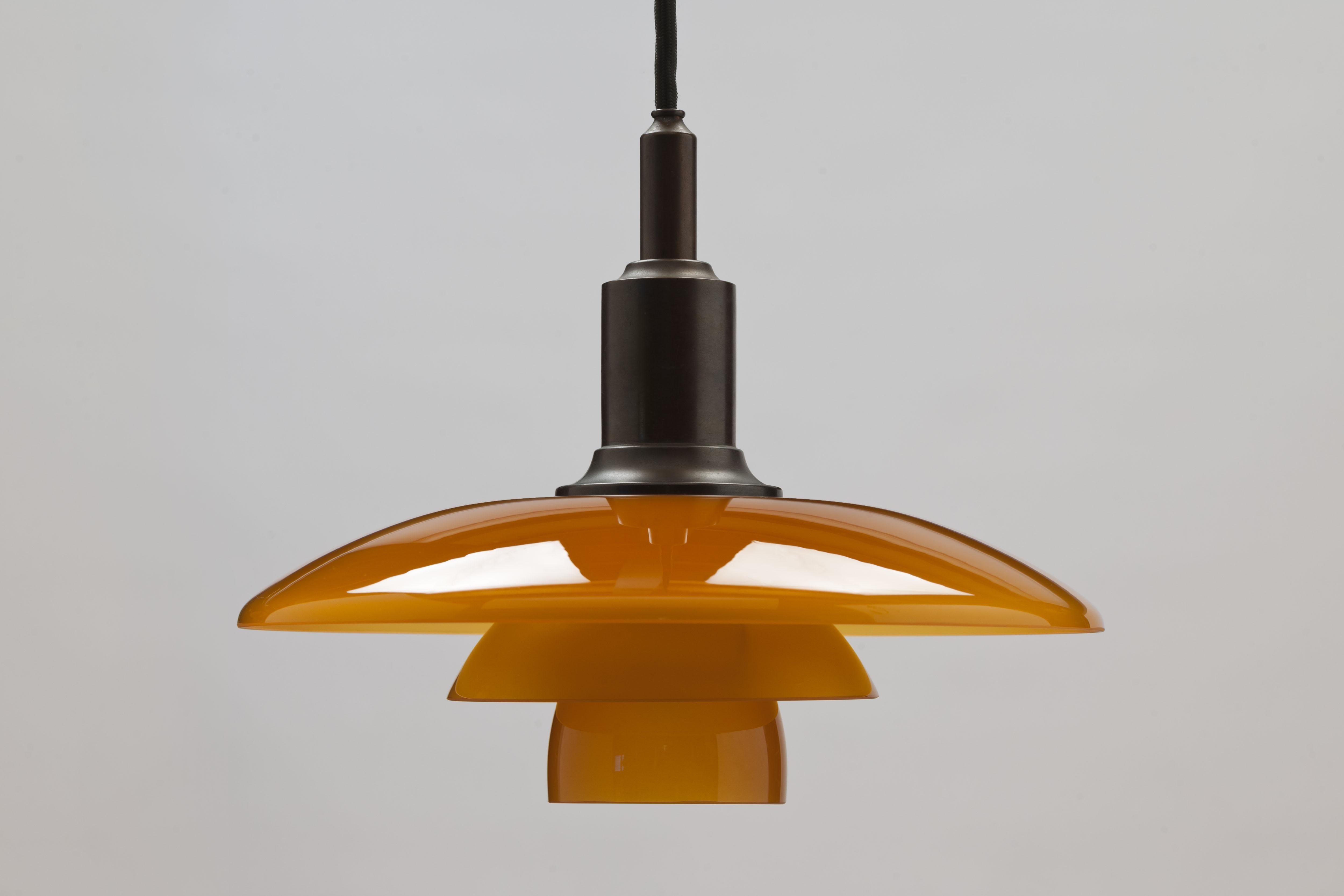 PH Amber glass shades on a PH3/2 browned brass pendant from the 1994 limited edition at the occasion of the 100th anniversary of the birth of Poul Henningsen.