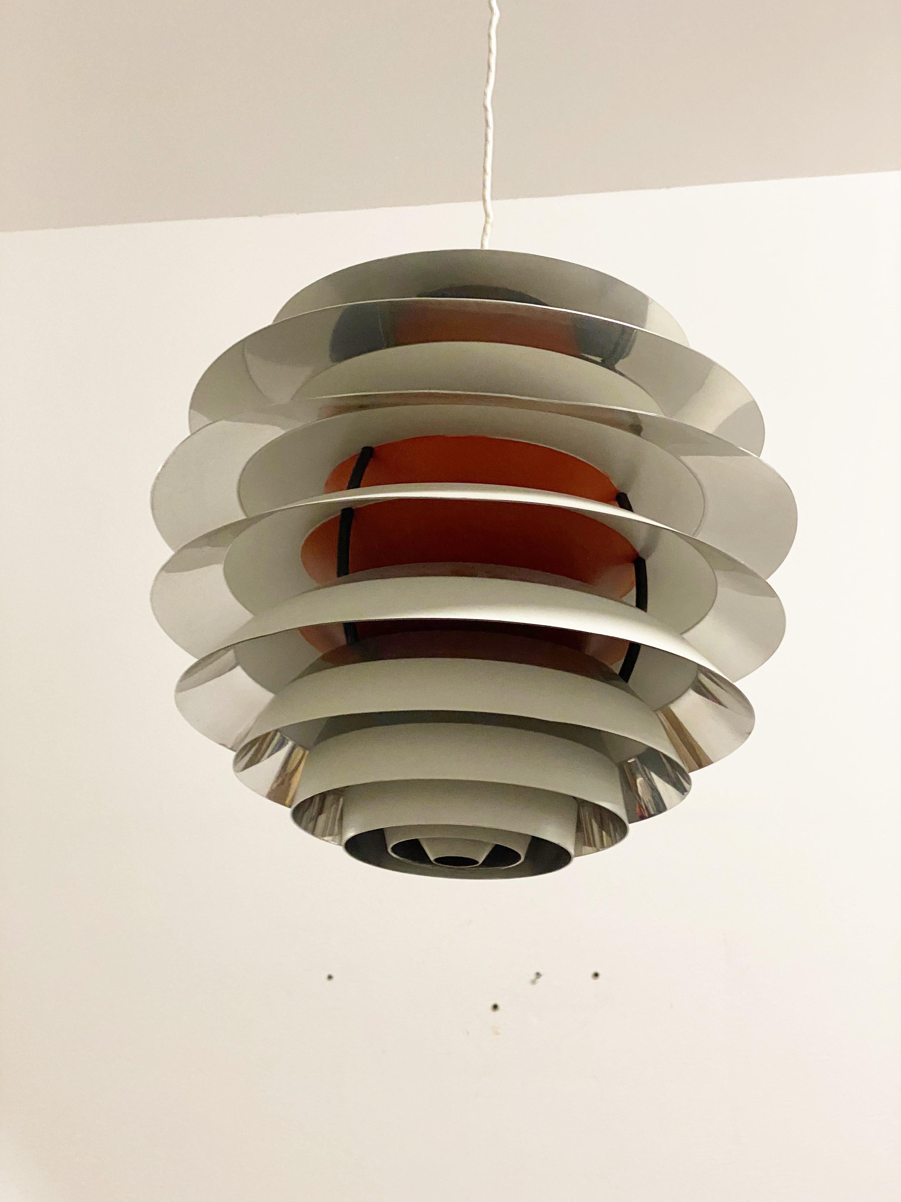 Aluminum lacquered white/orange and chromed parts with black lacquered brass fittings.
PH kontrast or snowball designed by Poul Henningsen in 1958-1962 and manufactured by Louis Poulsen. 

Literature: Light Years Ahead: The Story of the PH Lamp