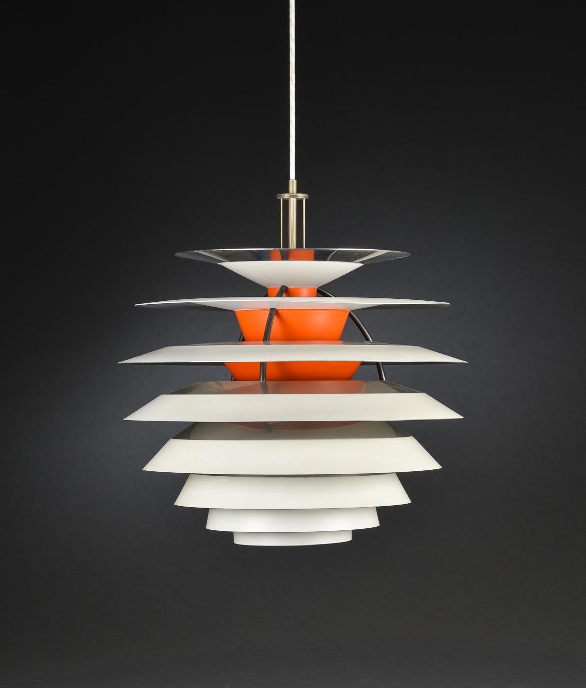 Poul Henningsen. ‘Kontrast’ lamp fitted with 10 shades, each with four different surfaces, adjustable pendant tube for adjustment of contrast lighting, fitted with fabric cord.
The lightbulb inside the lamp can be moved up and down. This ability to