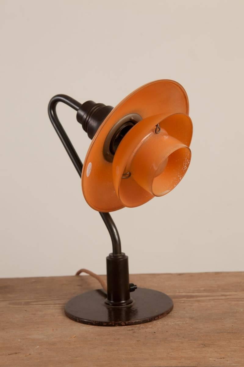 Poul Henningsen (1894 Ordrup, Denmark - Hillerød 1967), early, low miniature table lamp with 2/2 red frosted glass shades, patinated metal parts, brown bakelite, manufactured by Louis Poulsen, Copenhagen, Denmark, circa 1930

Literature: Light Years