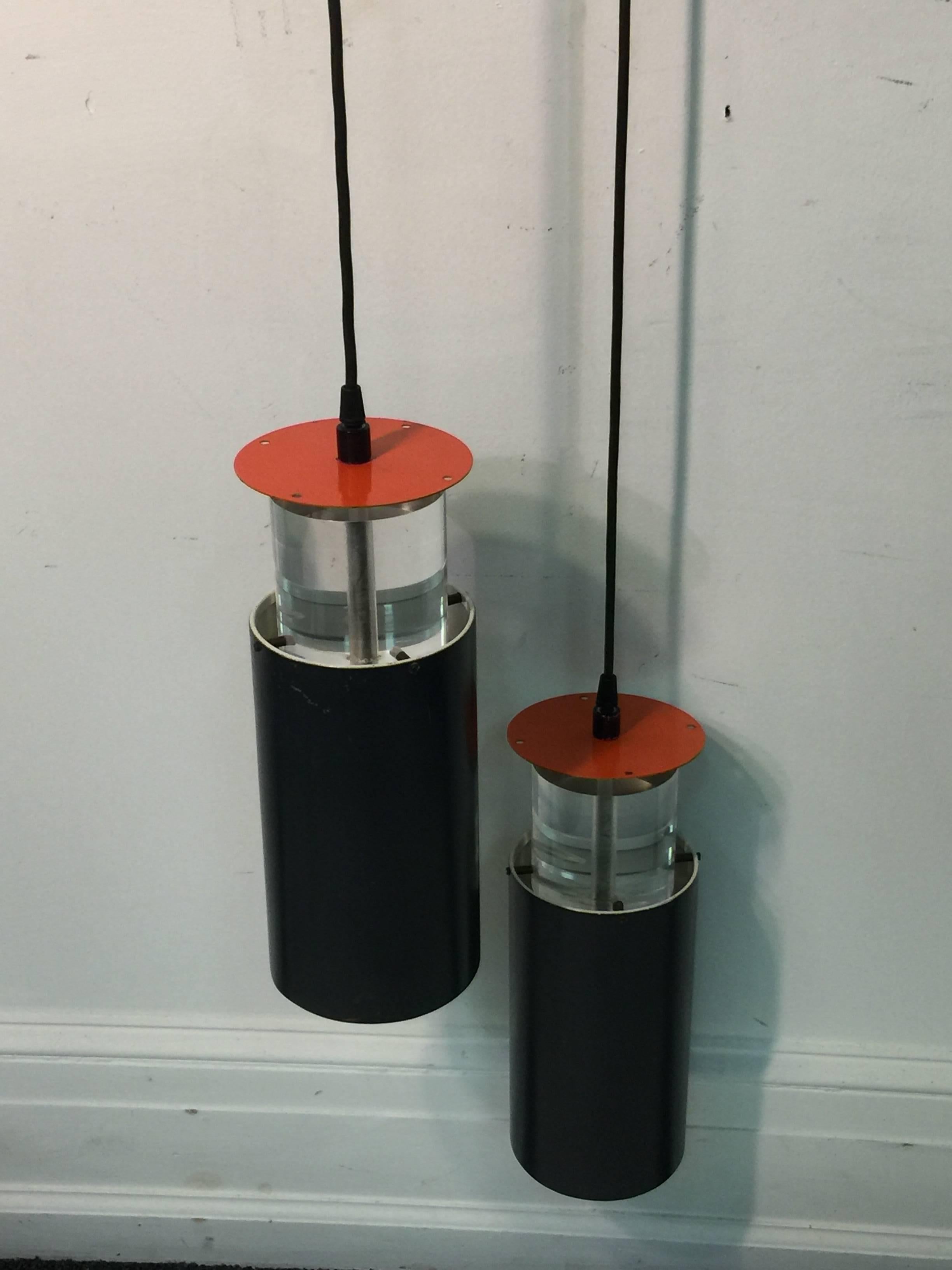 Poul Henningsen double pendant fixture with two hanging cylindrical fixtures in black enameled brass with a Pop Art orange enameled disc on top. The interior of the cylinder is Pop Art orange also. The clear thick Lucite cylinder is at the top of