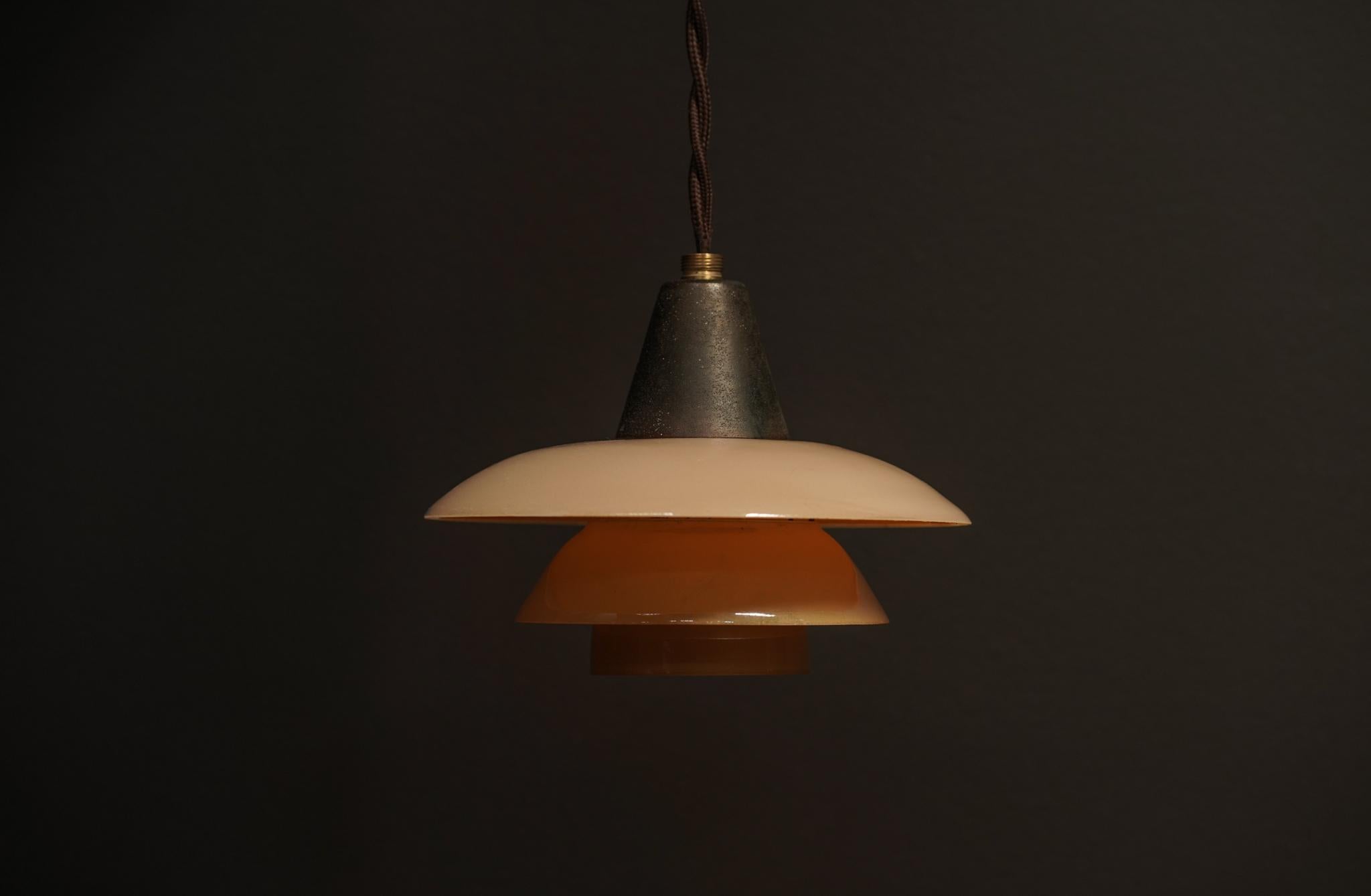 Un pendente Poul Henningsen Model 1/1 realizzato in rame con paralumi in vetro ambrato stratificato. Le sue dimensioni ridotte e il design a livelli creano una luce calda e diffusa.
Questo design iconico è perfetto per qualsiasi spazio.