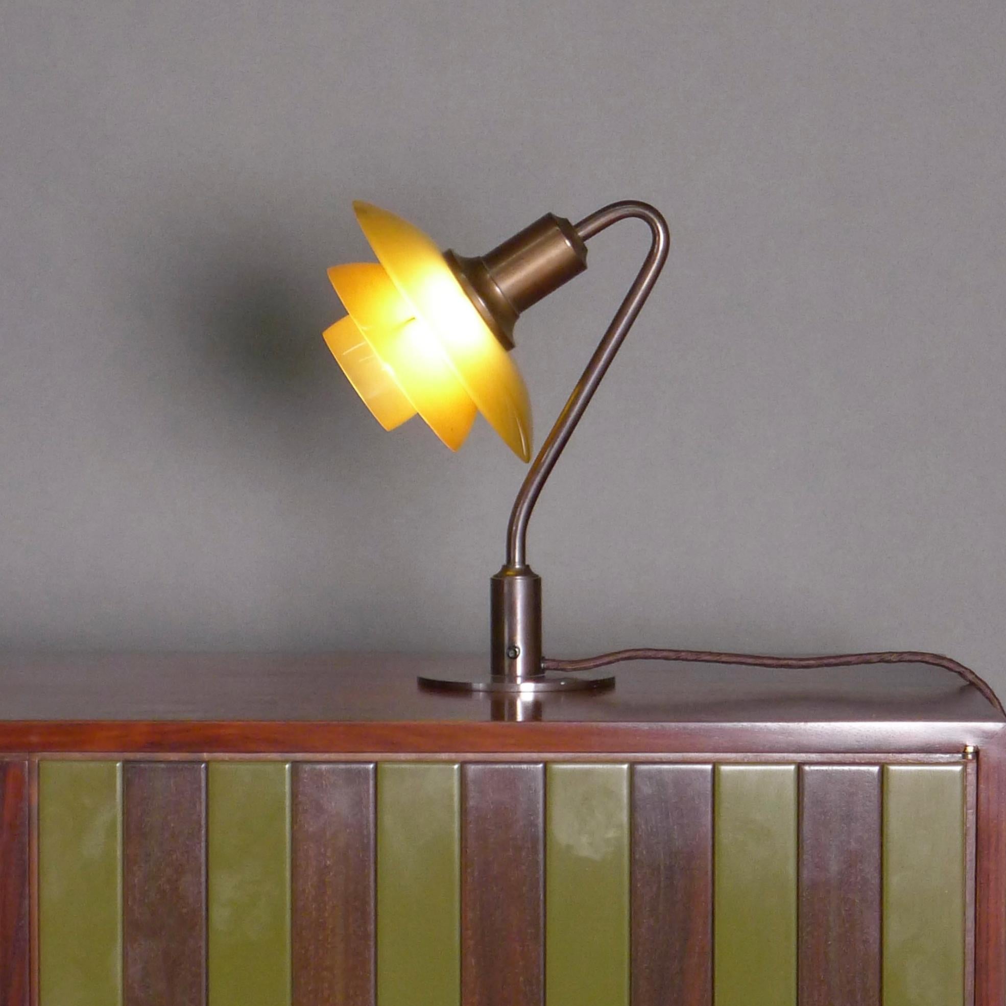 Poul Henningsen (1894-1967)
Miniature Table Lamp, Model 2/2
known as the ‘Vintergaekken' (Snowdrop) light
designed 1931 and produced 1931-1933 by Louis Poulsen, Denmark

Opaque amber glass shades, patinated brass stem and metal base with original