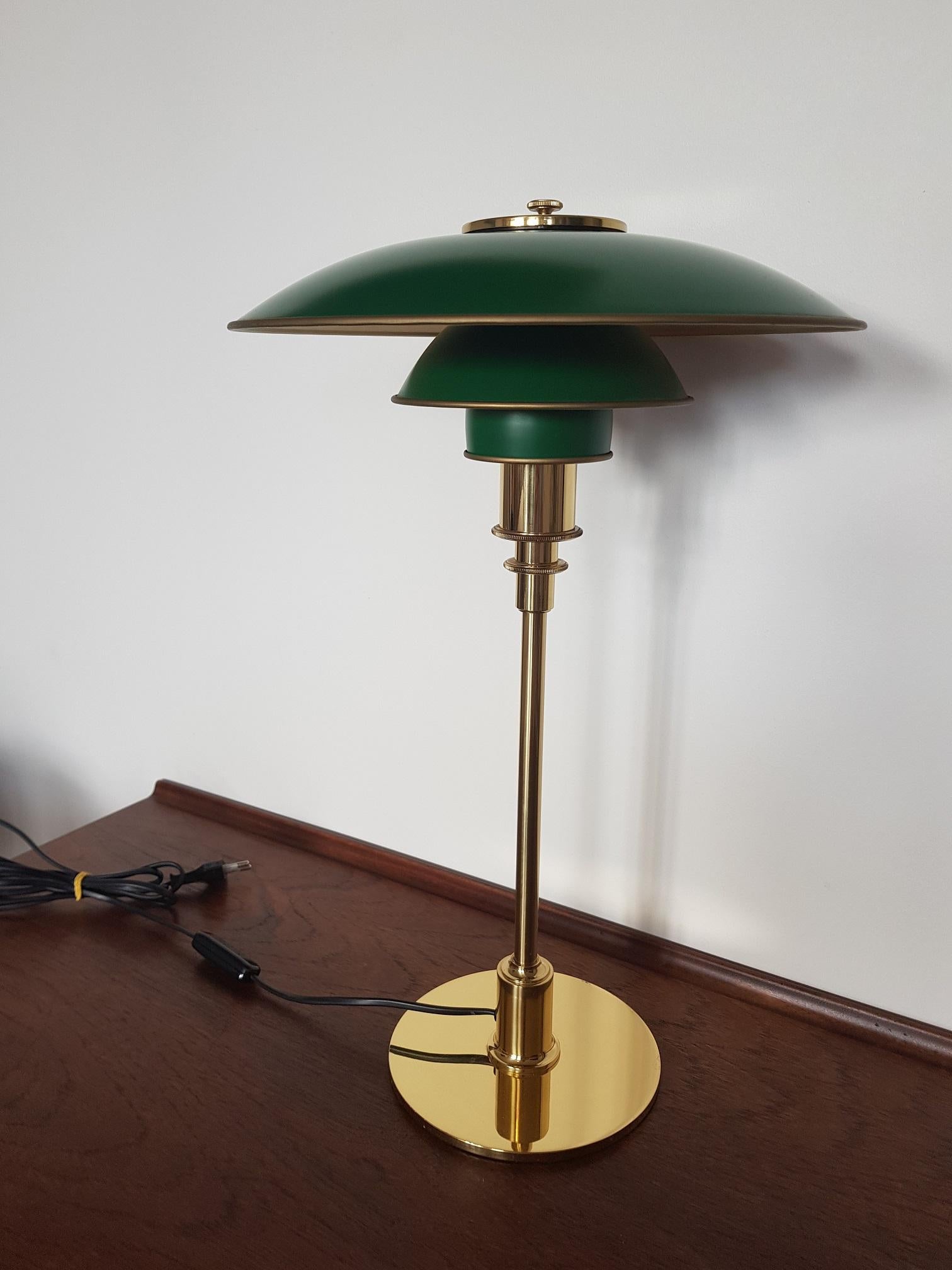 Green enameled shades on polished brass stem, foot and socket cover. Anniversary edition produced only for a year in the late 20th century. The iconic 3/2 table lamp decorates beautiful homes across the world and can be seen in movies and ads all