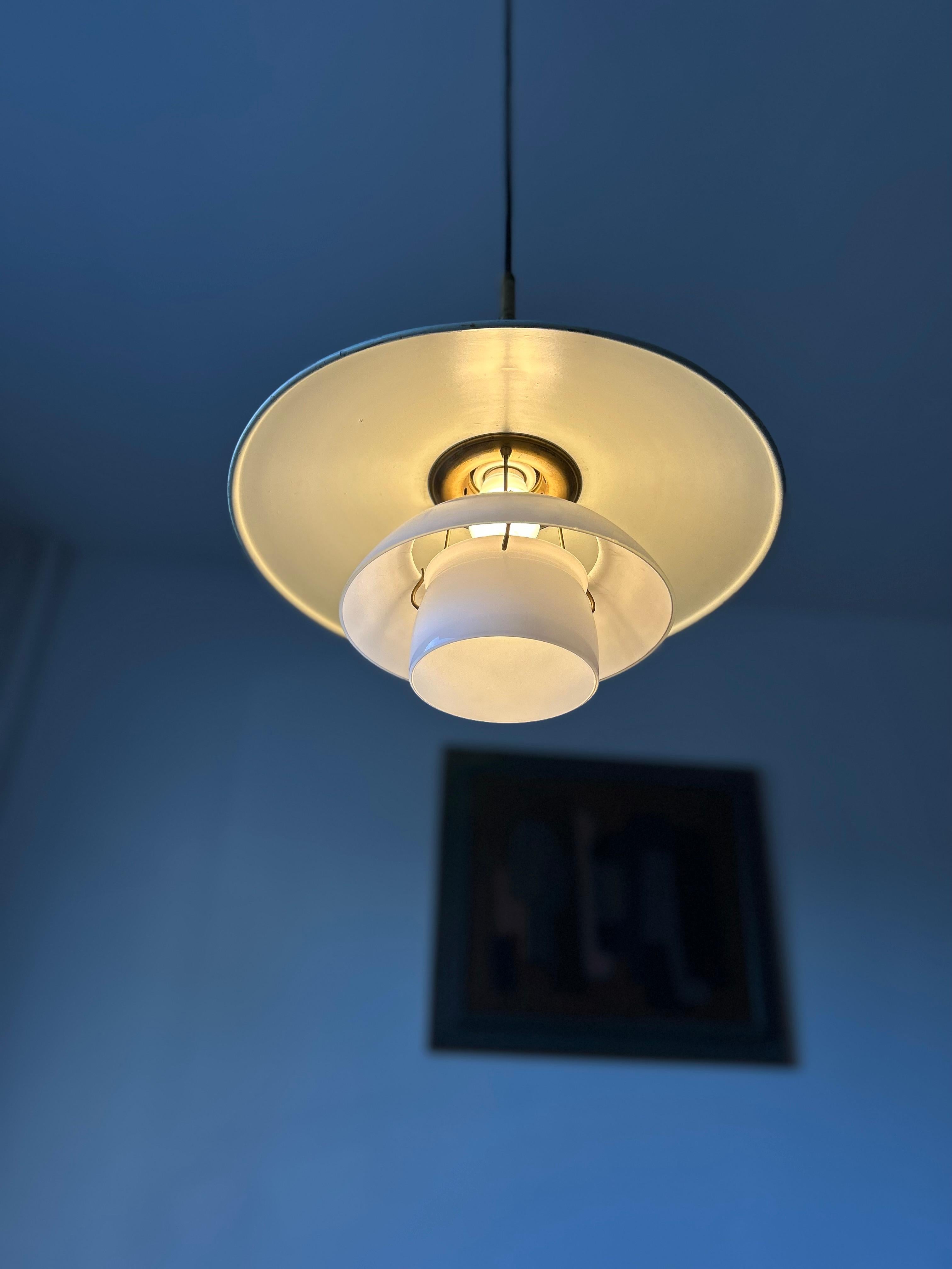 Rare Poul Henningsen PH 3,5/3 pendant with a top shade of white lacquered zinc and a middle and bottom shade in two layer opal glass and a top of beautiful natural patinaed brass.
The lamp is in good original condition.
The PH lamp is the perfect
