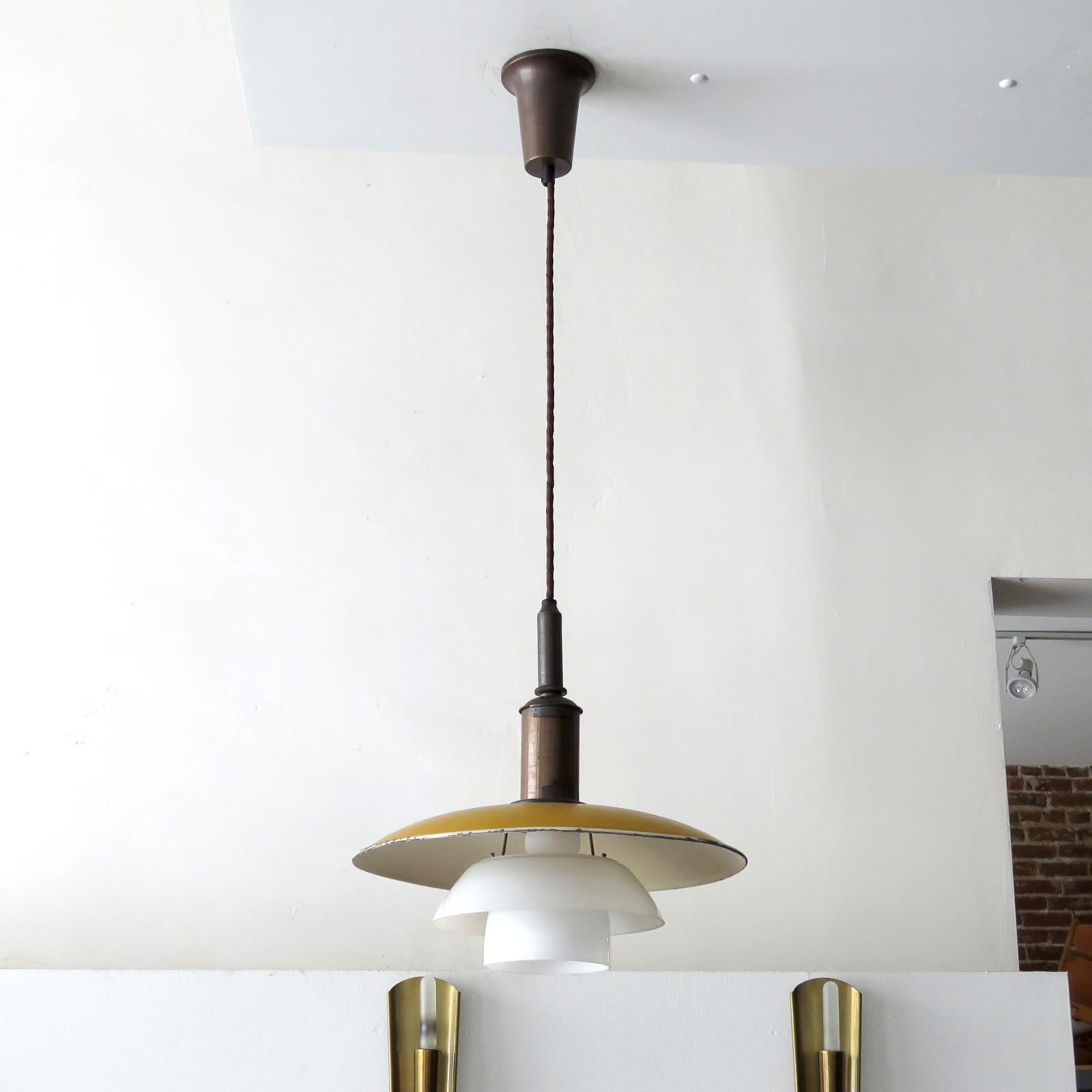 Rare 1930s PH-3.5/2 pendant light by Poul Henningsen for Louis Poulsen from 1930 with original shade set, top shade in dark yellow/orange painted metal and two double-layer opaline glass shades on the original copper bayonet socket housing, matching
