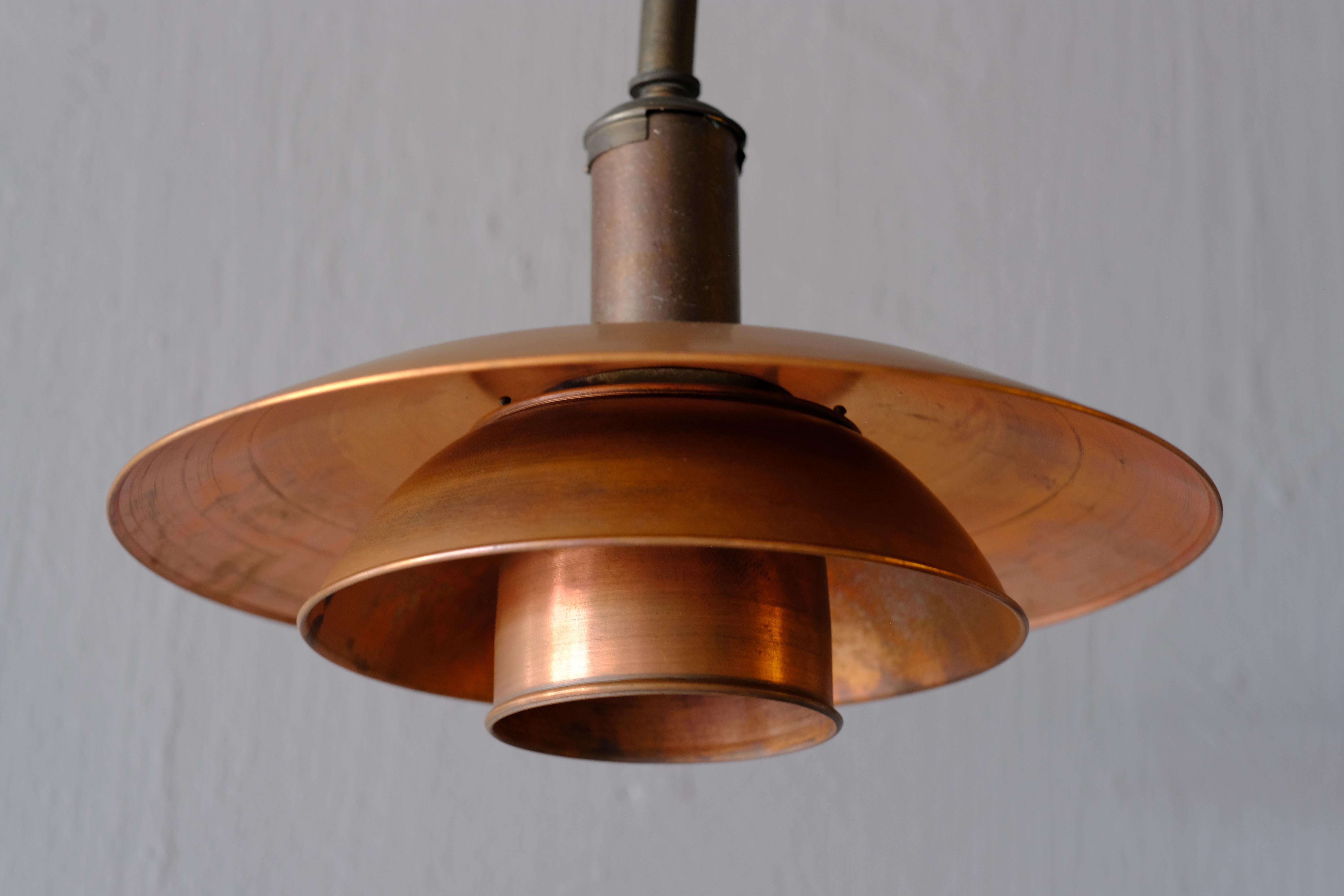 Very rare early “PH 4/3” pendant light by Poul Henningsen. It has wonderful patinated copper shades with a nickel plated socket cover with bayonet socket. The cast tripod shade holder is stamped “Patented”. Henningsen designed his iconic shade
