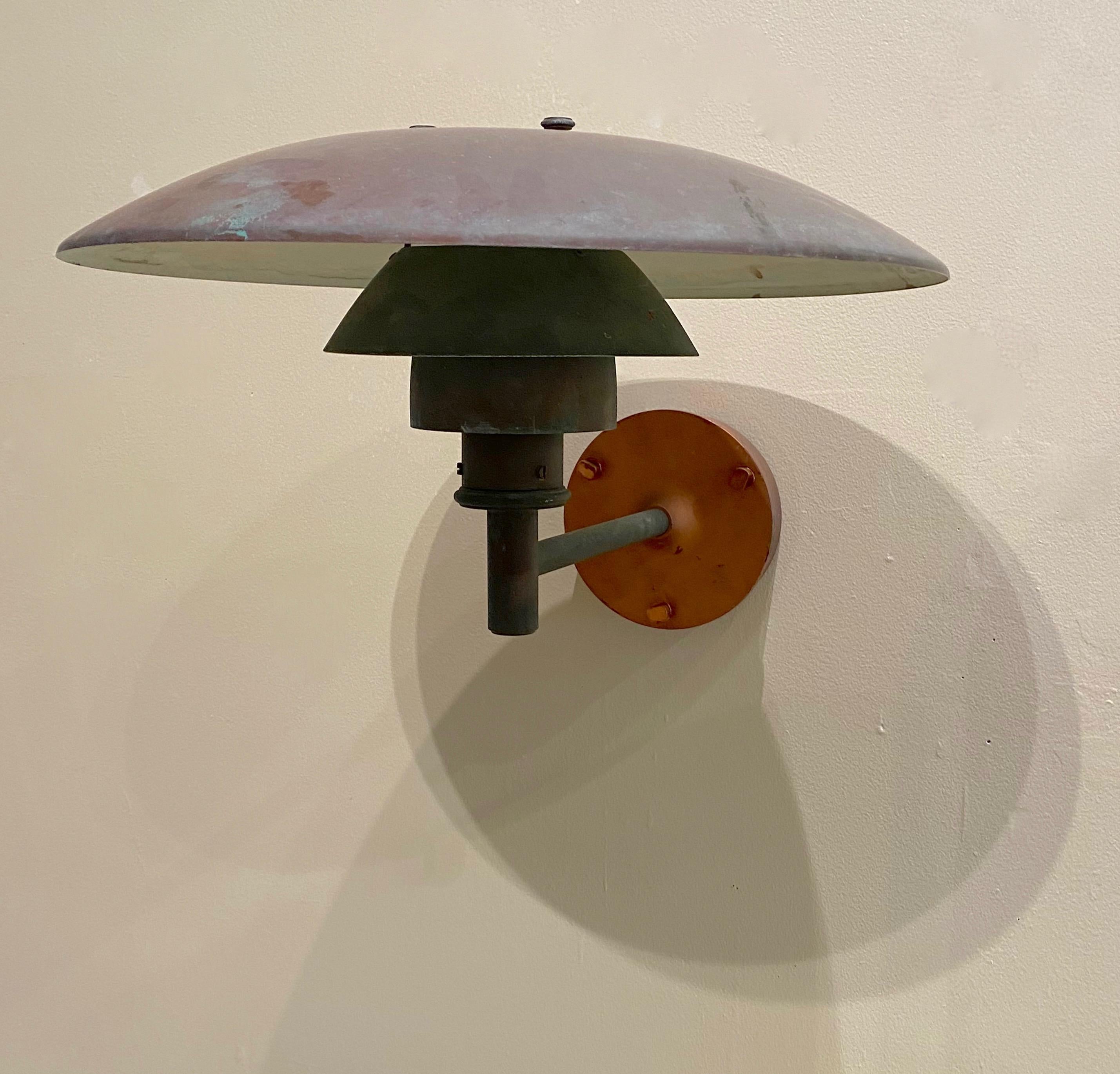 Solid copper wall sconce by Louis Poulsen the PH 4.5 / 3 and manufactured by Poul Henningsen of Denmark. The intent of the design by Poulsen was to eliminate glare with the concentric rings and the top shade that directs the light downward. The lamp