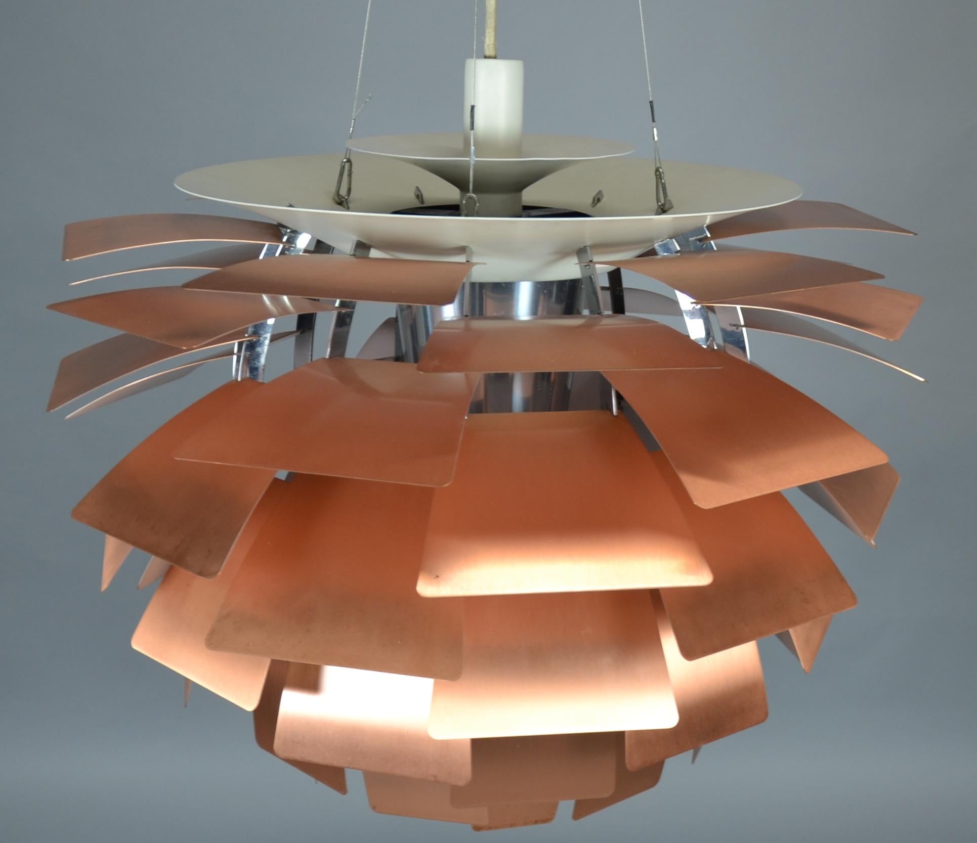 Design: Poul Henningsen
Design: from 1958
Manufacturer: Louis Poulsen
Condition: used
Model: PH Arichoke
Leaves inside white painted metal, outside copper. 
The lamp hangs on three steel cables.
E40 socket for max 300 watt bulb.
A baldachin