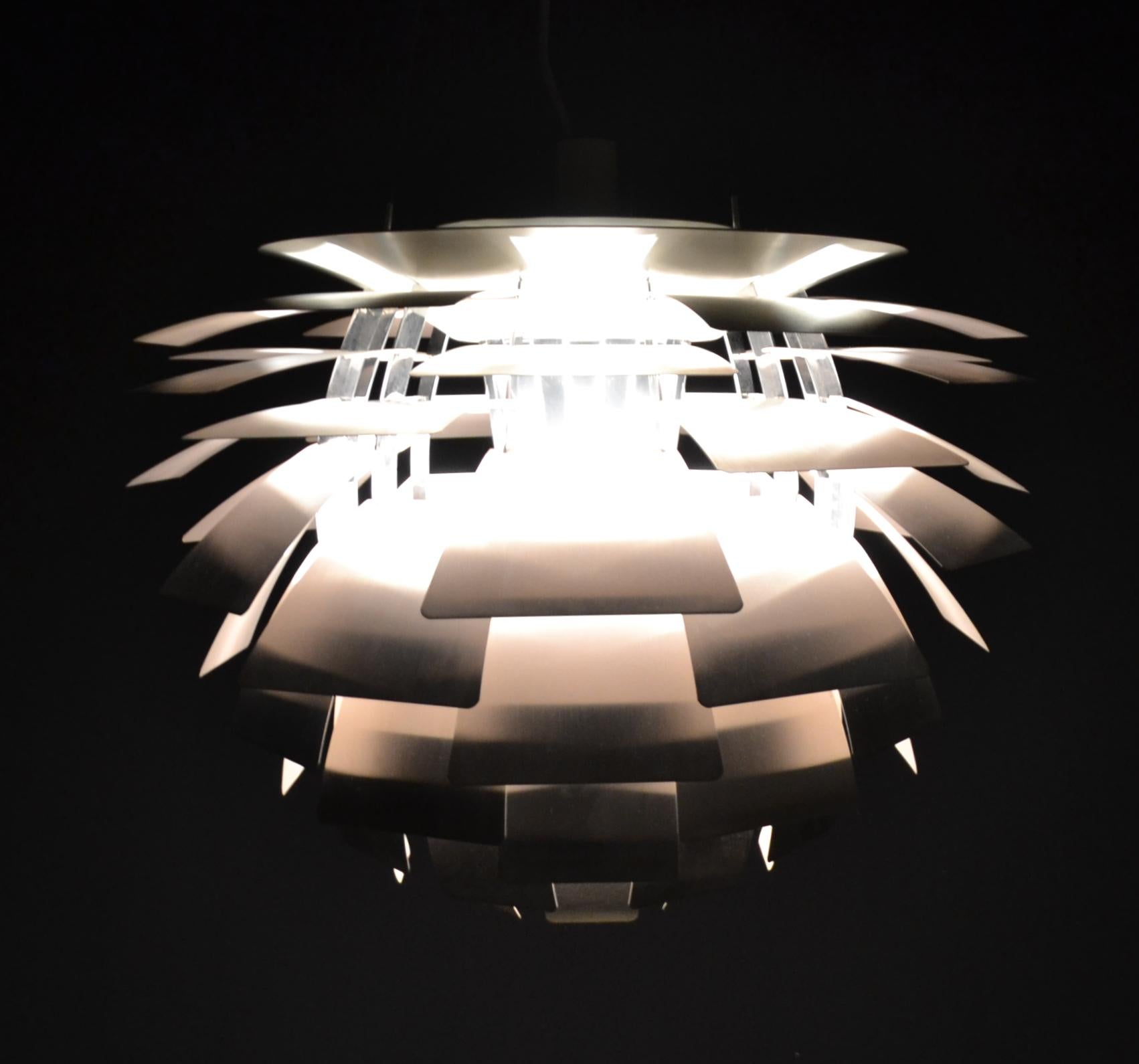 Design: Poul Henningsen
Design: from 1958
Manufacturer: Louis Poulsen
Condition: used
Model: PH Arichoke
Leaves inside white painted metal, outside stainless steel 
The lamp hangs on three steel cables.
E40 socket for max 300 watt bulb.
A
