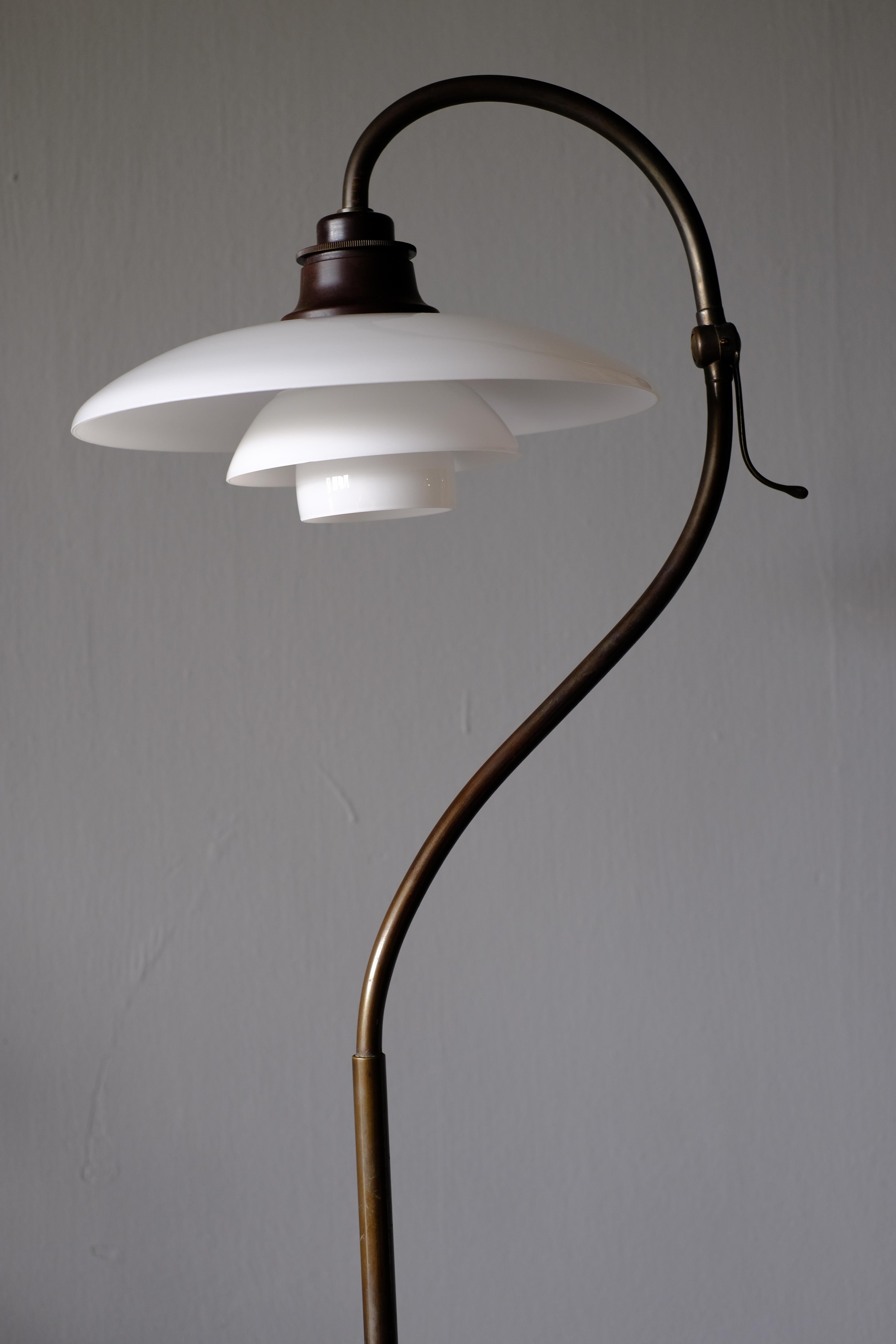 Very rare 'The Question Mark'. Standard lamp designed by Poul Henninsen for Louis Poulson. It has a browned brass socket cover and stem, painted iron foot, top with tilt function and wire shade holders with 3/2 two-layer glass shade set. This glare