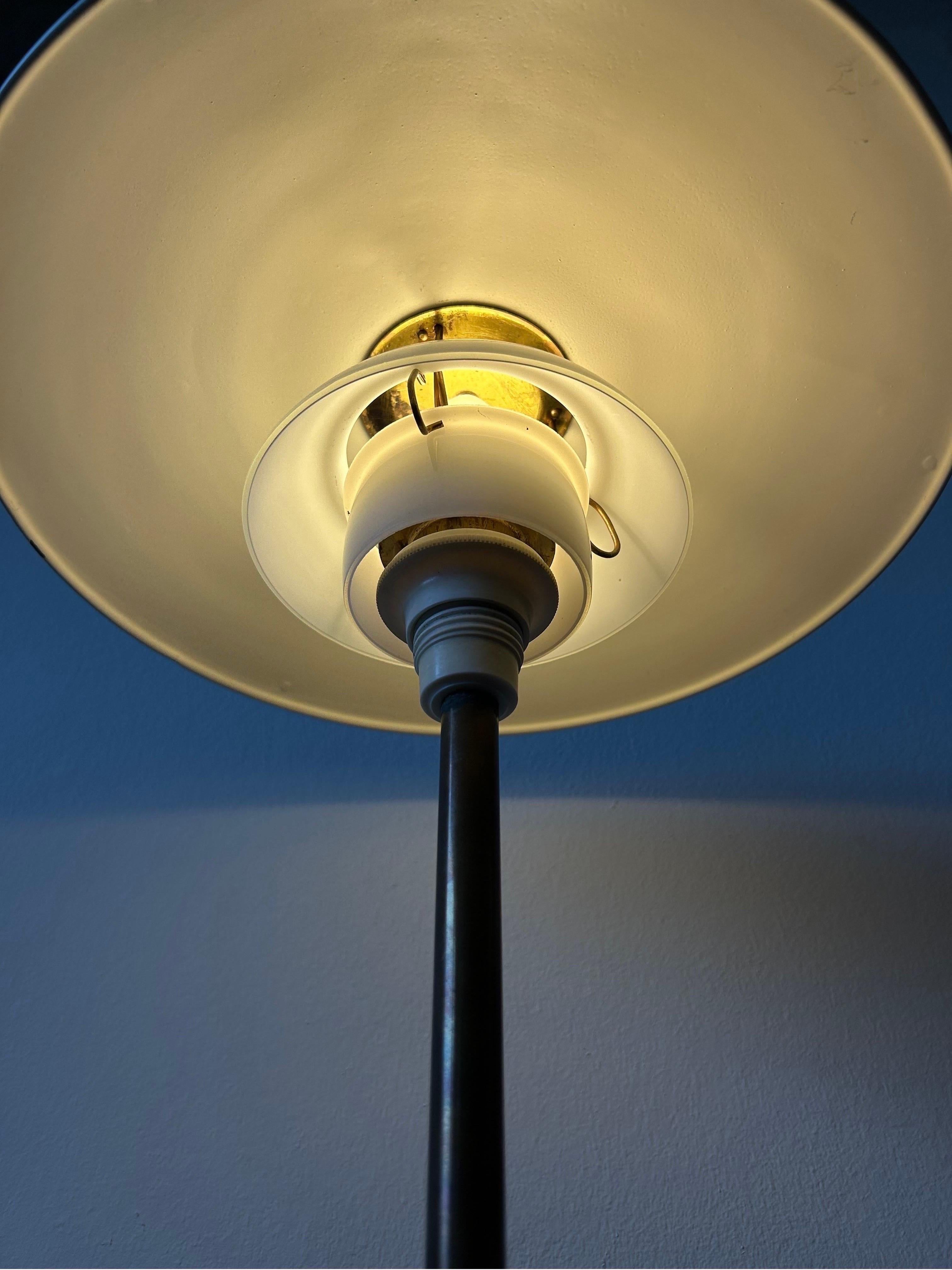 Lampe de table Poul Henningsen modèle 3/2,5 fabriquée par Louis Poulsen dans les années 1940. La structure de la lampe comporte une douille en bakélite blanche et un boîtier d'interrupteur, une tige en laiton foncé, une base en métal laqué blanc, un