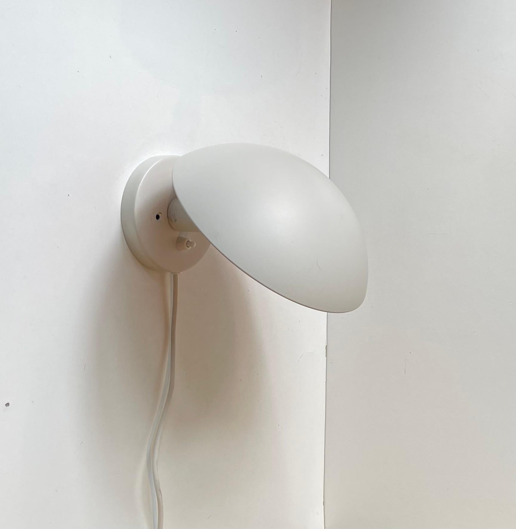 Applique blanche PH Hat conçue par Poul Henningsen à la fin des années 1970. Cet exemplaire particulier a été fabriqué par Louis Poulsen au Danemark au début des années 2000. Elle est dotée d'un abat-jour réglable en angle, d'une laque rose