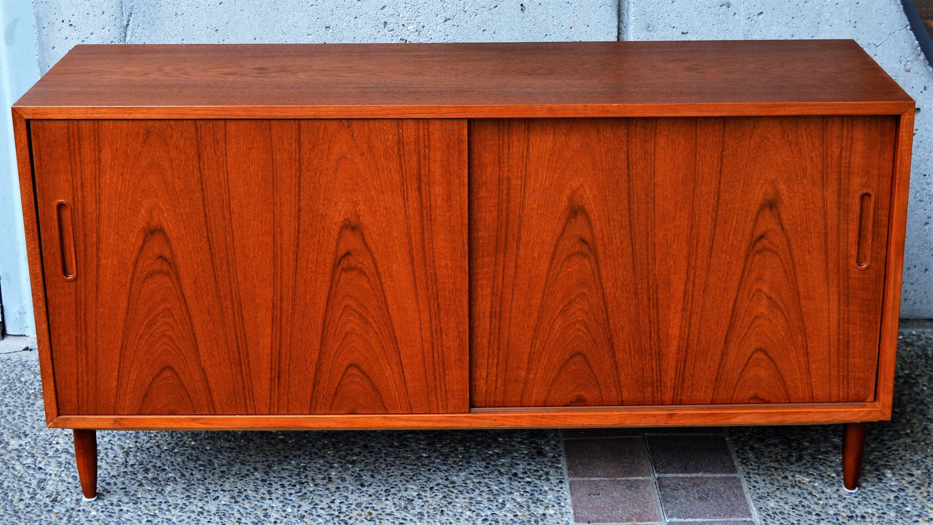 This lovely Danish modern teak buffet or credenza with smaller proportions is all wood construction from the, 1960s. Featuring a birch interior, nice and light in contrast to the rich patina of the body, the interior features three adjustable