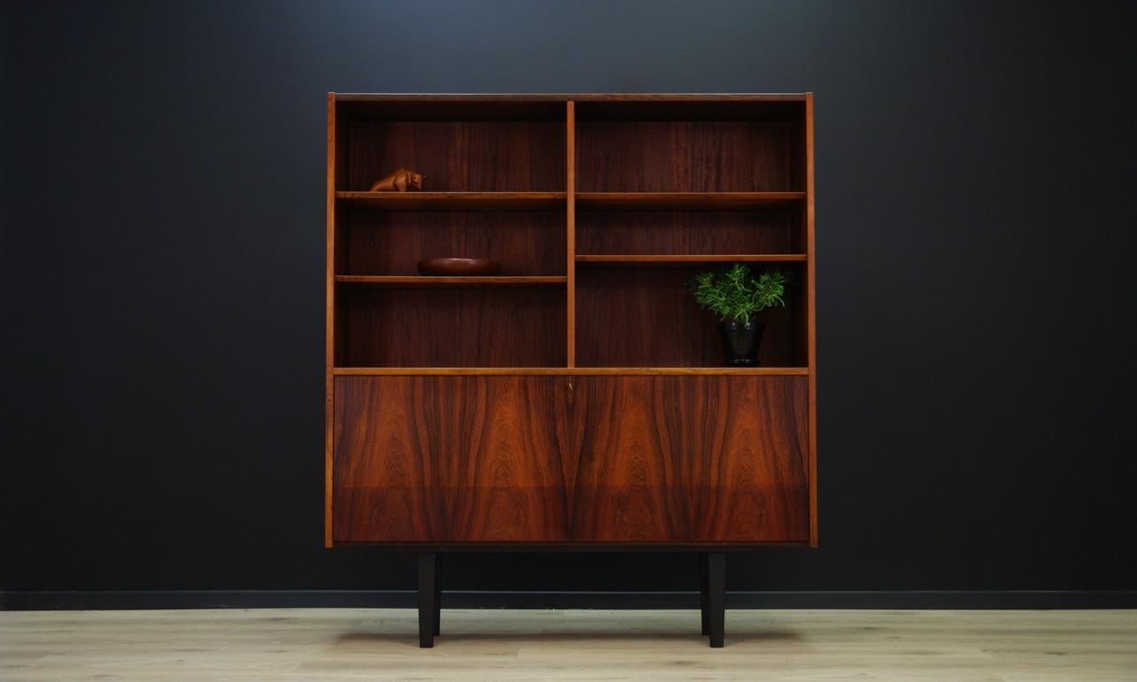Library, bookcase from the 1960s-1970s. Scandinavian design, a form created by Danish designer Poul Hundevad for the Hundevad & Co. manufactory. The surface is veneered with a rosewood. It has four adjustable shelves and a bar at the bottom.