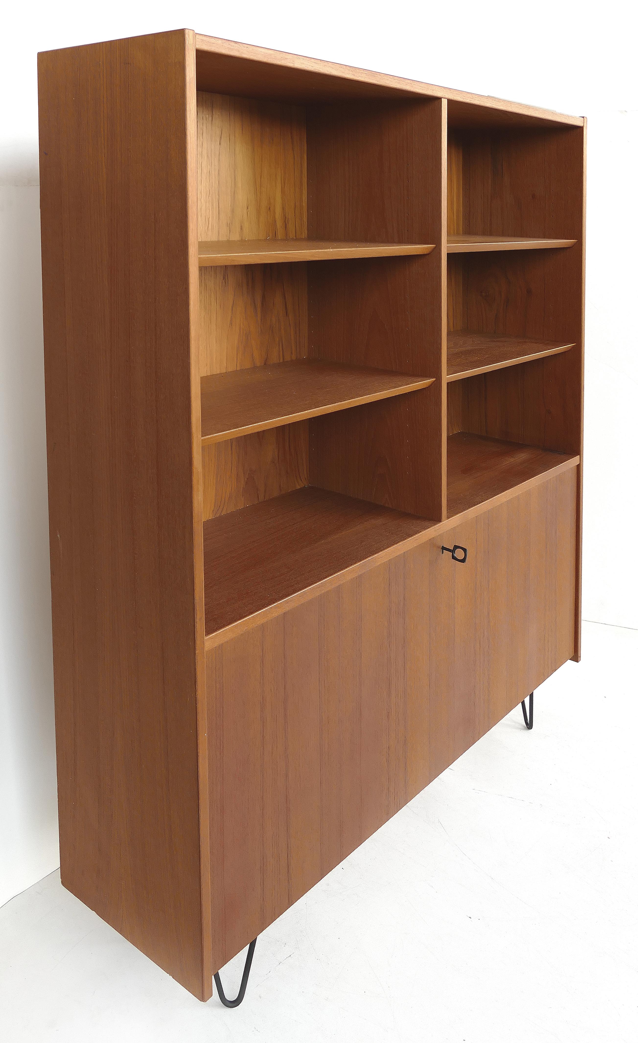 Poul Hundevad Danish modern teak wall unit on hairpin legs

Offered for sales is a Danish modern teak wall unit by Poul Hundevard from Sweden. The unit has a keyed drop front secretary compartment with slotted shelves within. The upper portion has