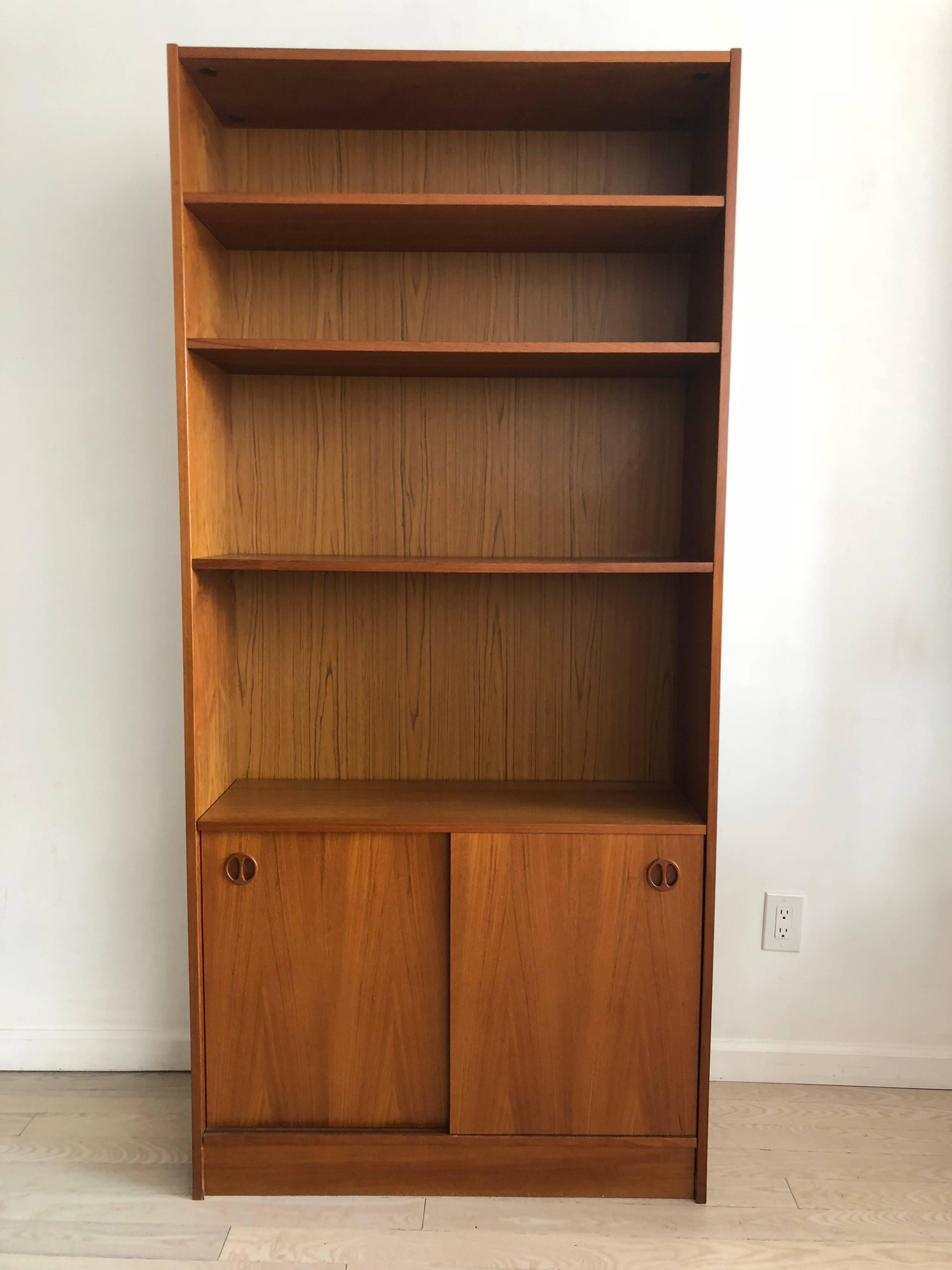 Danish midcentury teak bookcase by Poul Hundevad. Excellent condition. Adjustable shelves. Pretty circle wood pulls. Sliding cabinets below.