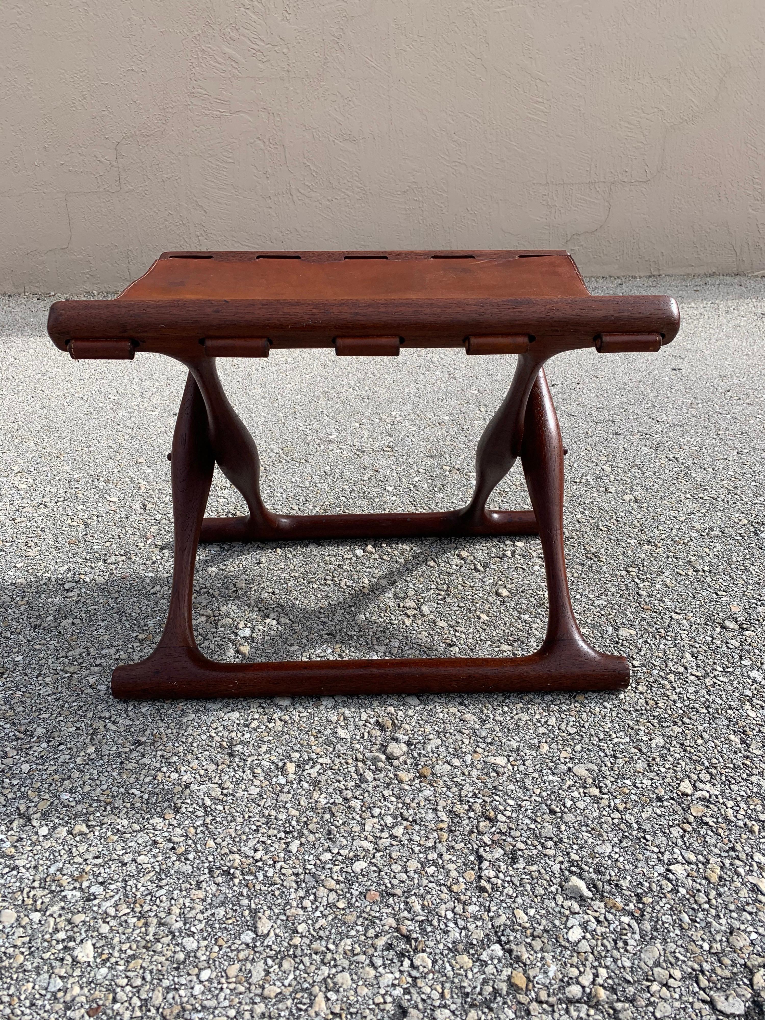 Danish teak folding stool designed by Poul Hundevad. In original condition. Simple, elegant and natural design. Great patina in the finish and leather. No damage. Would fit well in Mid Century Modern, minimalist, and natural themed rooms.