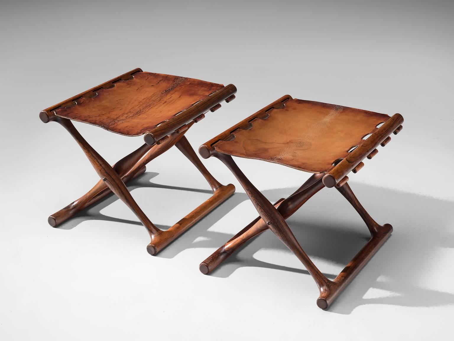 Poul Hundevad, PH43 stools 'Goldhøj', rosewood, cognac leather, Denmark, 1960s. 

This set of stools is designed and made by the Danish designer Poul Hundevad. The stools can be folded and are made of solid rosewood and high quality cognac leather