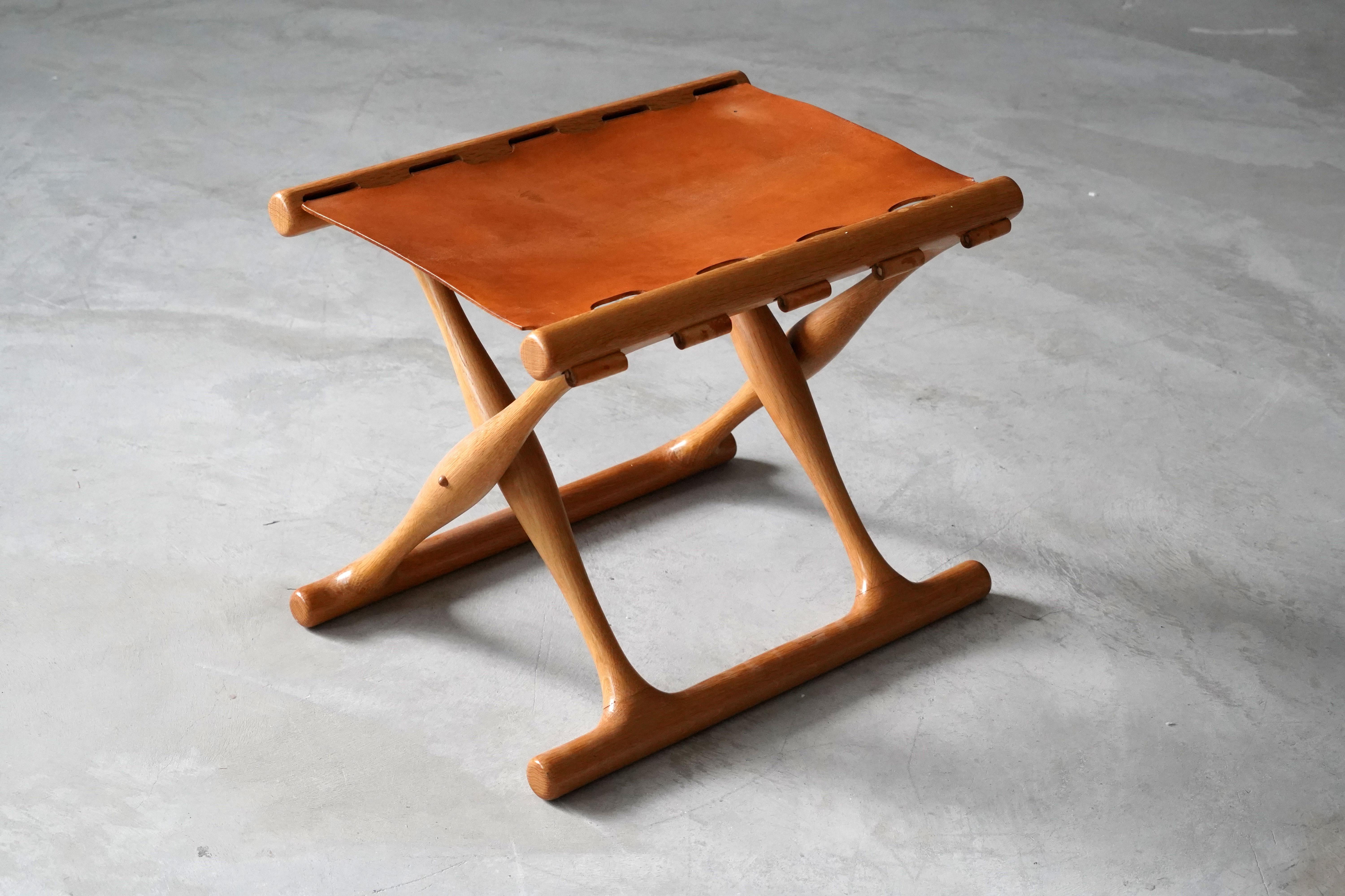 An early production “Guldhøj” folding stool, designed by Poul Hundevad and produced in the studio of the artist. Executed in finely sculpted oak and original natural leather. 

Other designers of the period include Kaare Klint, Ole Wanscher, Finn