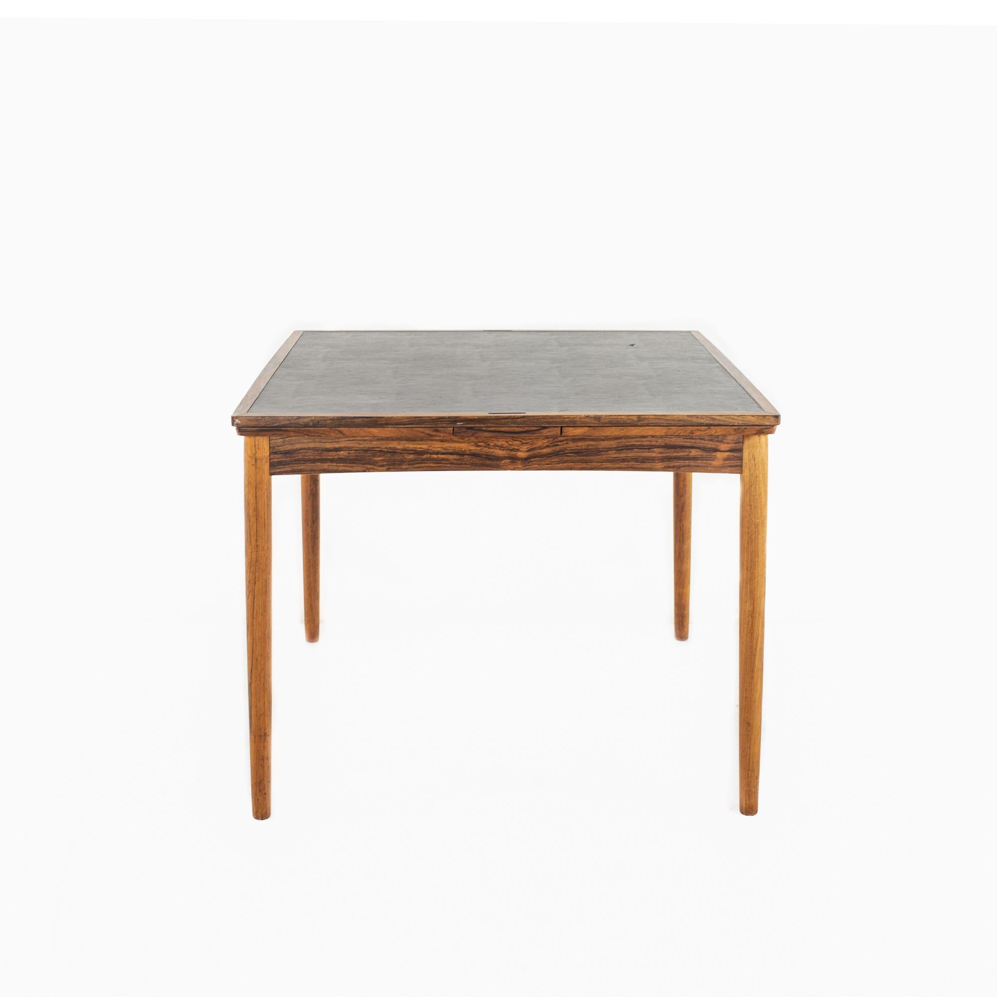 Poul Hundevad mid century rosewood expanding game table

The table measures: 35.25 wide x 35.25 deep x 27 high, with a chair clearance of 23.5 inches; each leaf is 14 inches wide, making a maximum table width of 63.25 inches when both leaves are