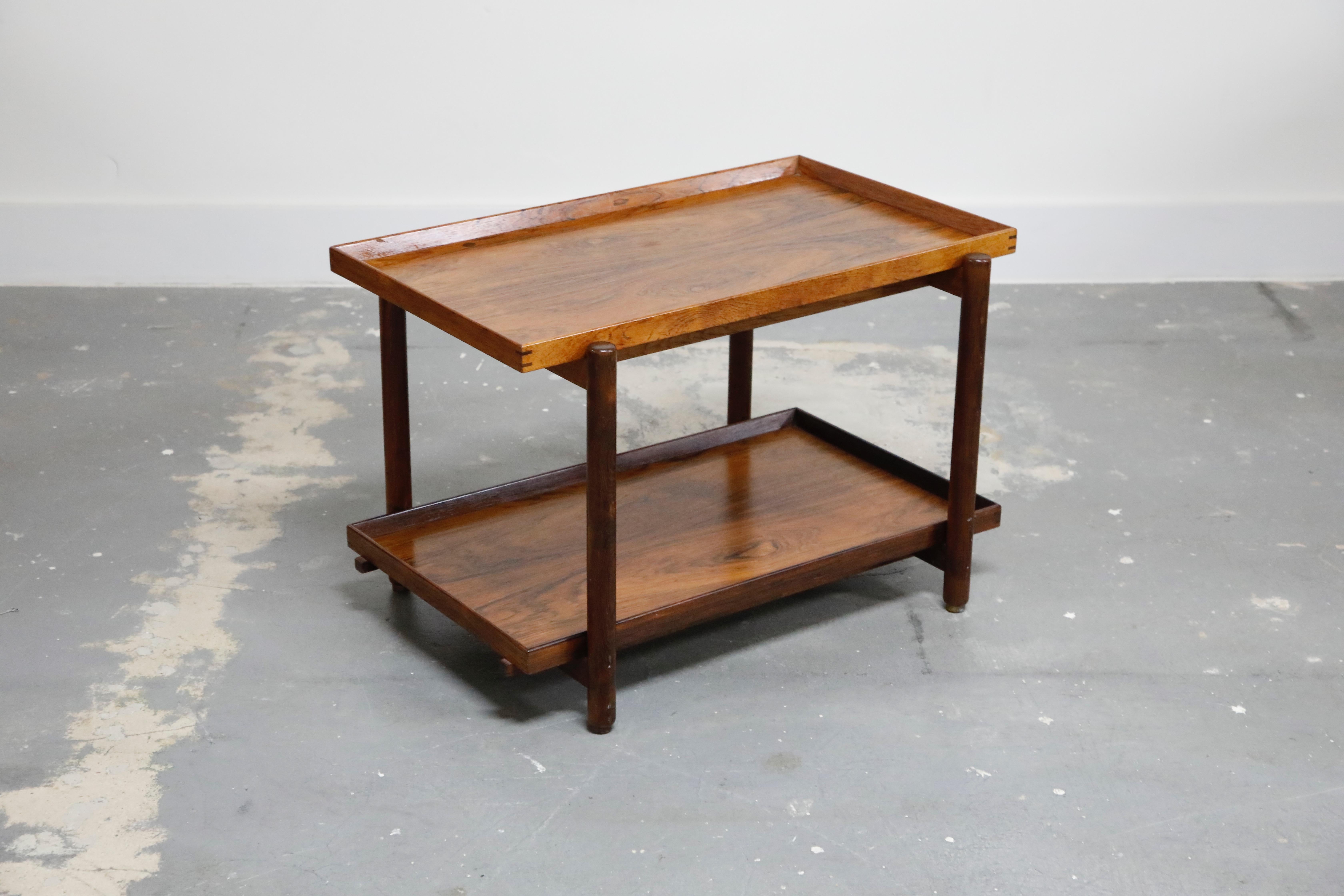 Sleek Danish warm rosewood grained modular bar cart by Poul Hundevad that is perfectly depictive of the Mid-Century Modern era. This adaptable piece has can be reconfigured with the use of both trays on the upper level as shown in the photos