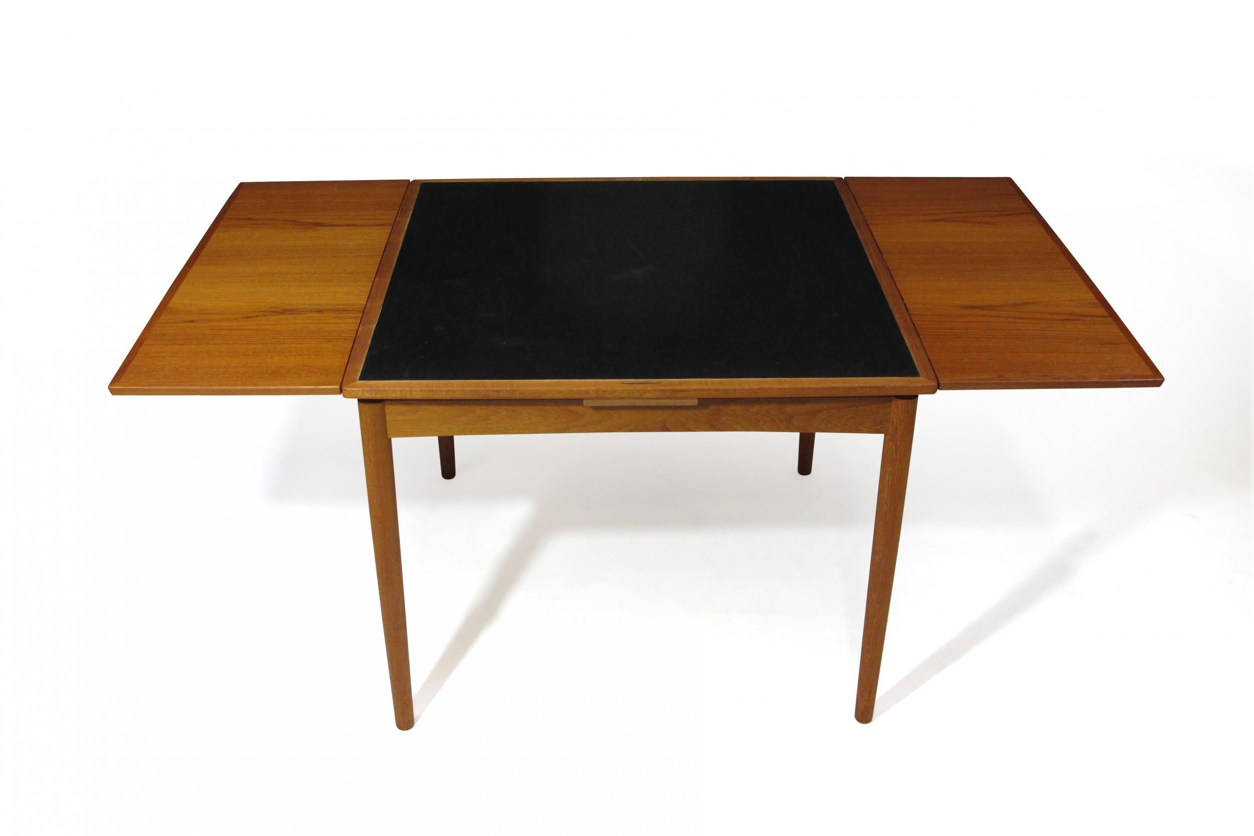 Teak reversible top dining table designed by Poul Hundevad for Hundevad Moblefabrik, model 24, circa 1958, Denmark. The table is crafted of teak, with fine edge banding around the edge and book matched grain, with two pull-out leaves on either end