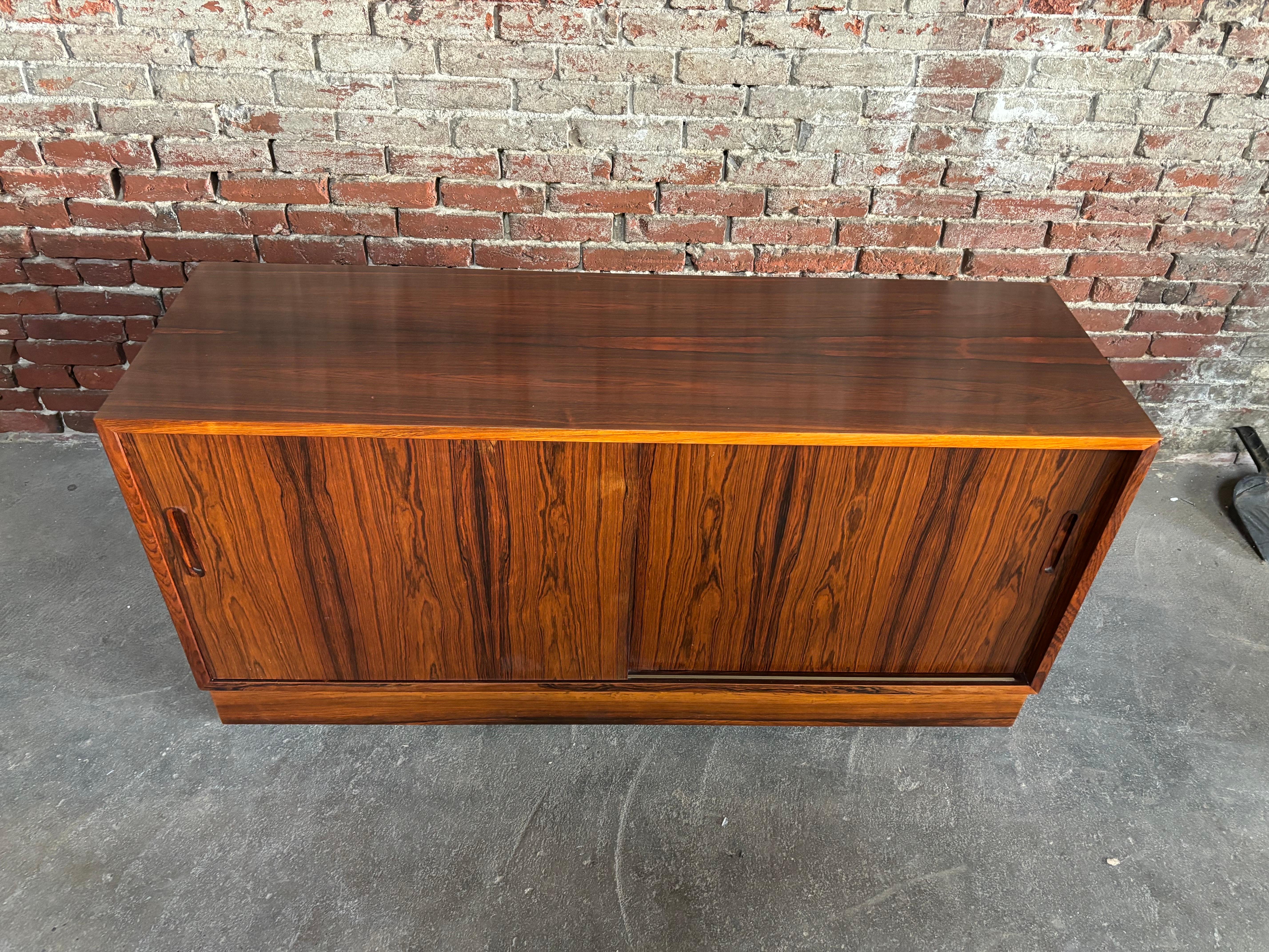 Credenza Poul Hundevad 2 Puertas Palisandro.  ¡Dos armarios disponibles!  ¡Gran tamaño que mide 54,5 de ancho!  Las puertas se abren fácilmente para mostrar un cajón extraíble y una balda a la izquierda, y una balda ajustable a la derecha.  En