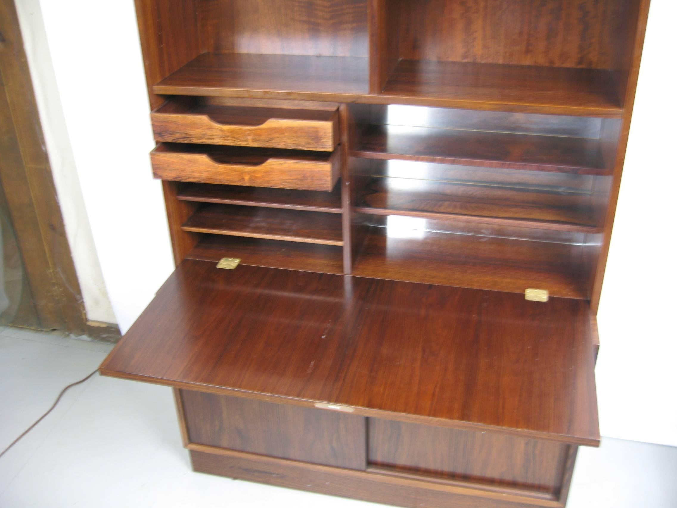 Stunning rose wood book case or desk. Sliding door on the bottom with file draw and shelving. Two pieces. Top is shelves with a locked drop down desk on the right. Measures: Top is 50.75 in x 42.5 in x 12 in deep (the top sits back), desk is 18.25