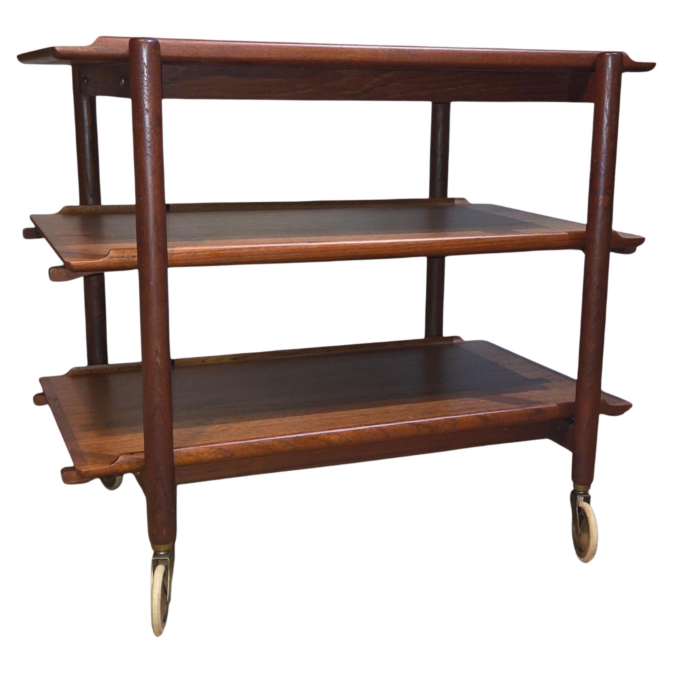 Cet élégant chariot roulant réglable des années 1960, créé par le designer danois Poul Hundevad, illustre le savoir-faire raffiné et la polyvalence du design scandinave du milieu du siècle dernier. Fabriquée en teck richement grainé, cette pièce