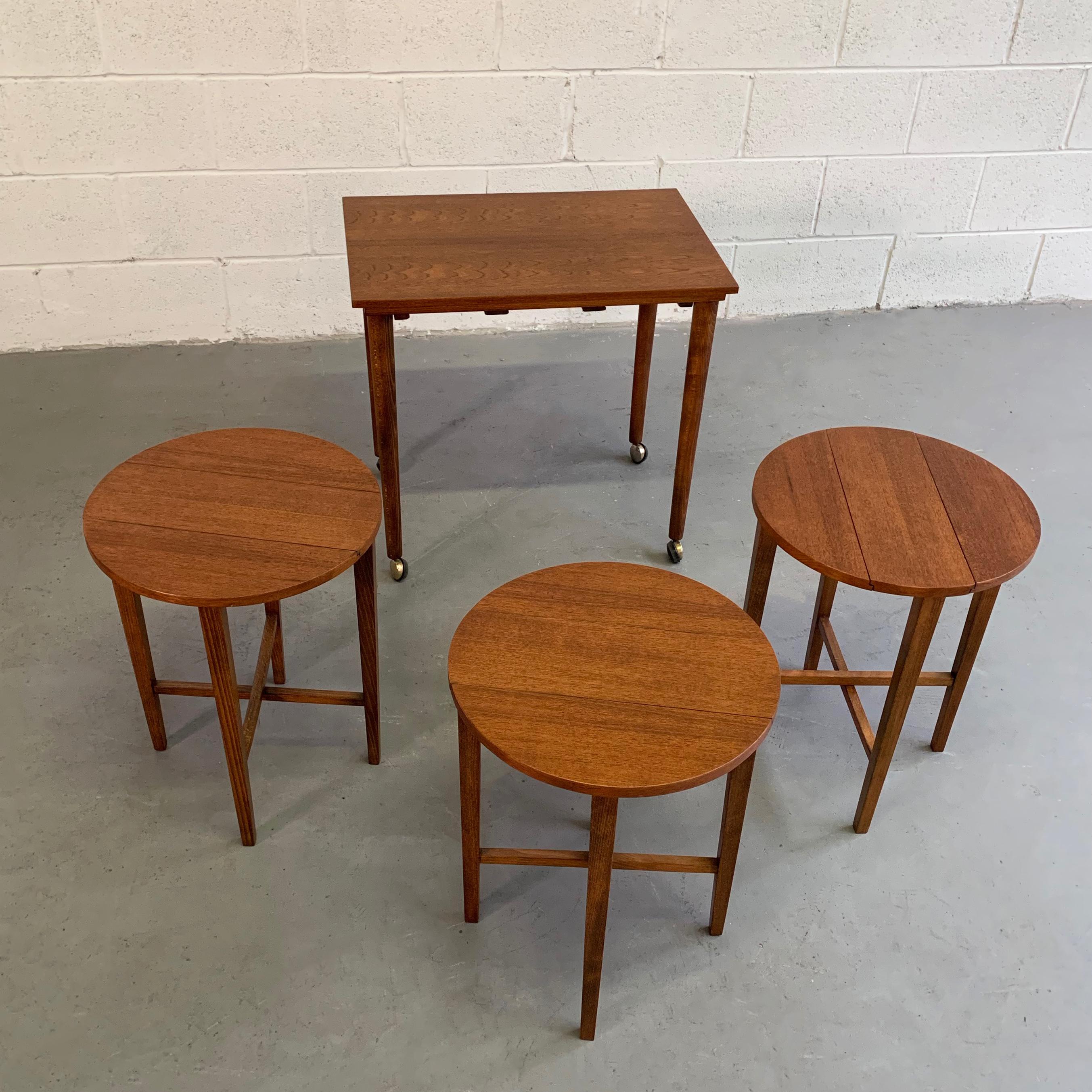 Set of 4, teak, nesting tables designed by Poul Hundevad for Novy Domov features 3 folded, round side tables, measuring 15 inches diameter x 19 inches height, tucked underneath the top table for occasional use.