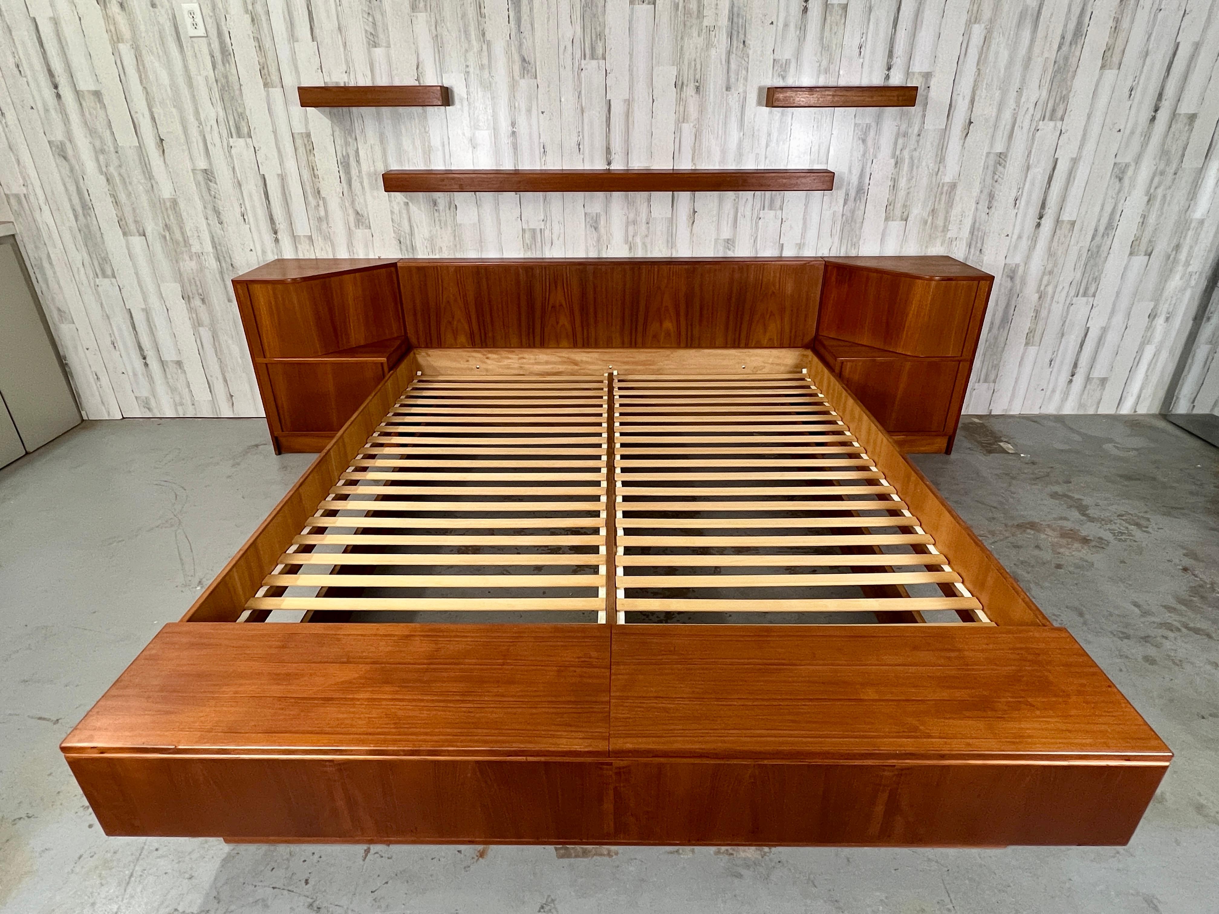 Poul Hundevad teak platform bed with tambour door nightstands & floating shelves. This is a huge statement bedroom piece with all the bells and whistles. Huge tambour door nightstands that can fit tons of items. Front storage trunk for more