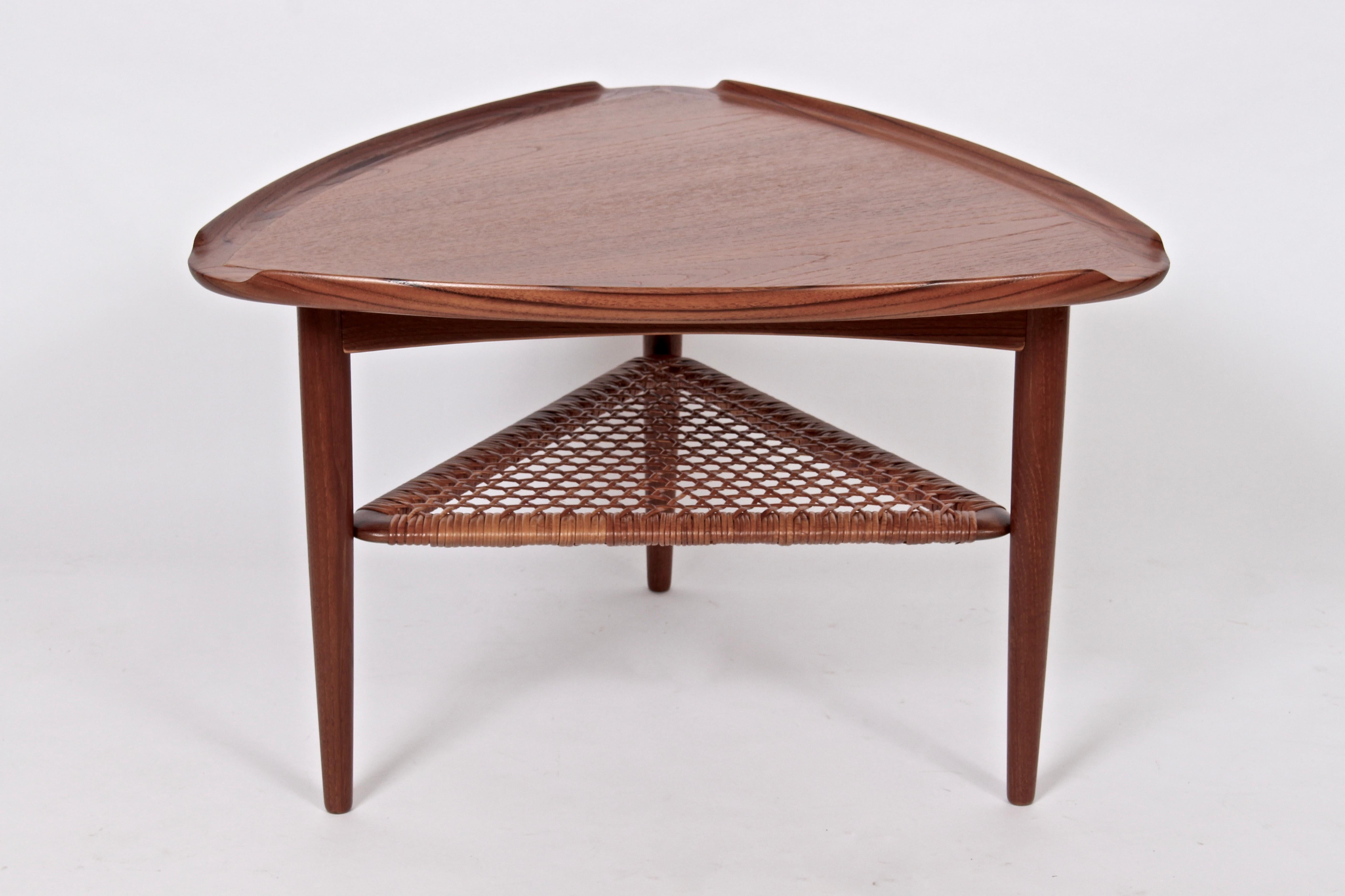 Danish modern Poul Jensen for Selig Guitar Pick Coffee Table, Occasional Table in Walnut and Woven cane. Featuring a smooth seamed and lipped triangular Walnut surface, lower shelf wrapped in woven rattan. Legs (21 D x 21 D). Classic. Timeless. Fine