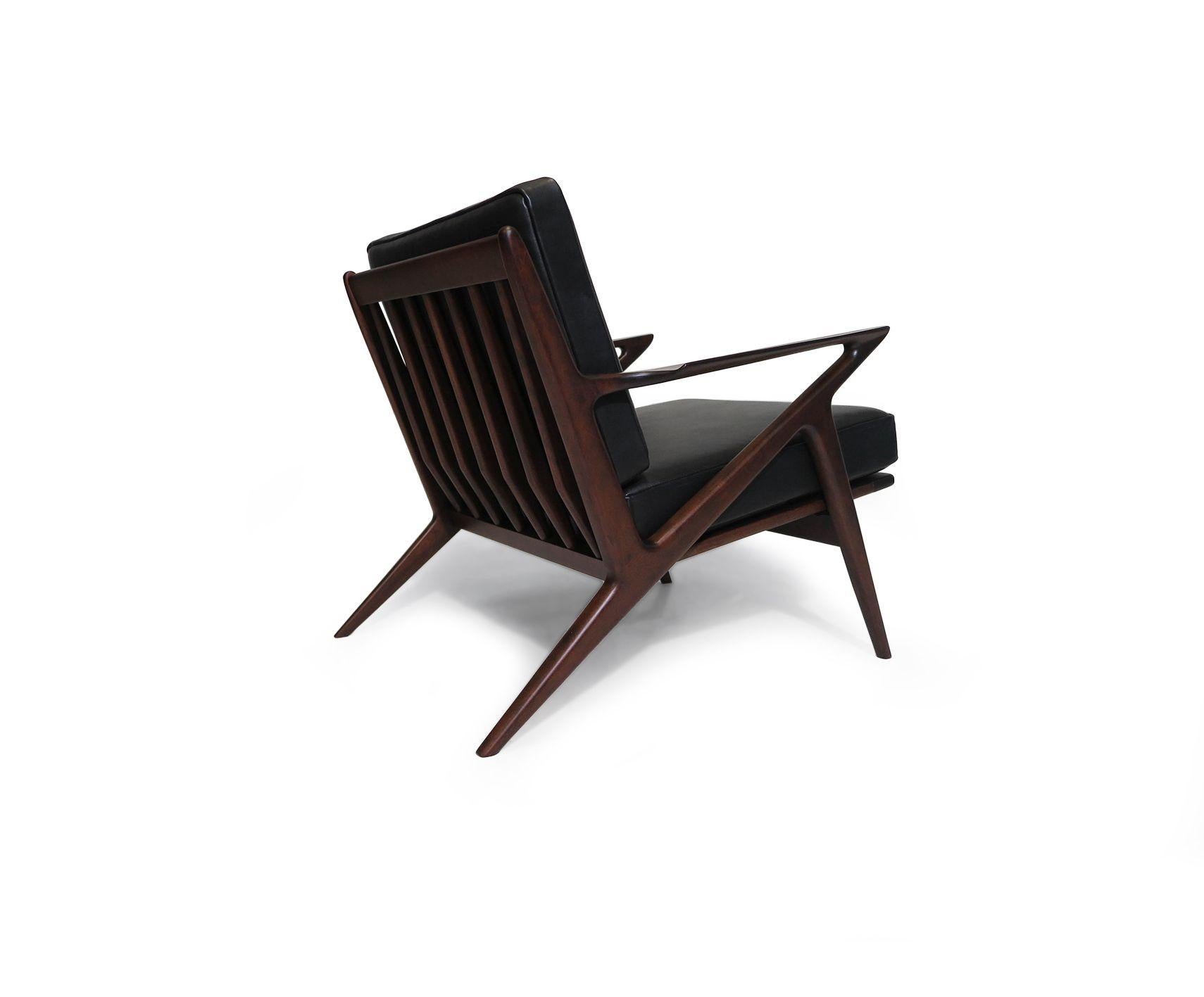 Single Mid-century Danish sculptural lounge chair designed by Poul Jensen for Selig, showcasing a dramatic angular form with rosewood-stained beech frame and newly upholstered black leather cushions. The chair has been fully restored and in